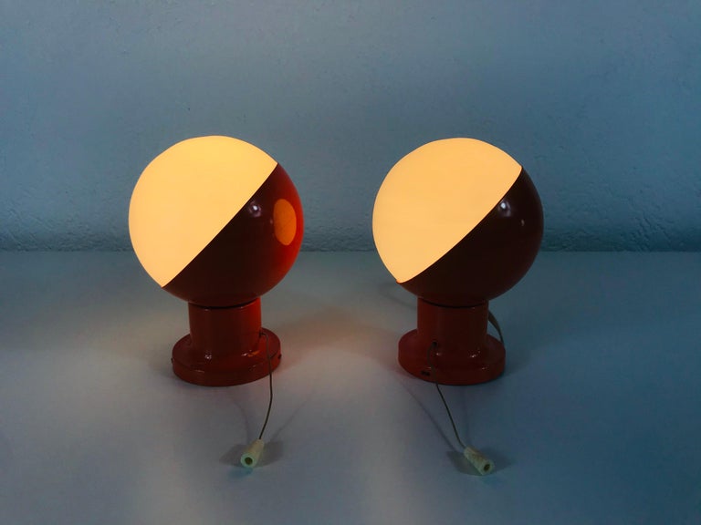 A pair of midcentury wall lamps by Kaiser made in Germany in the 1960s. It is fascinating with its Space Age design and white opaque balls. The red body of the light is made of full metal. 

The light requires one E27 light bulbs.
  