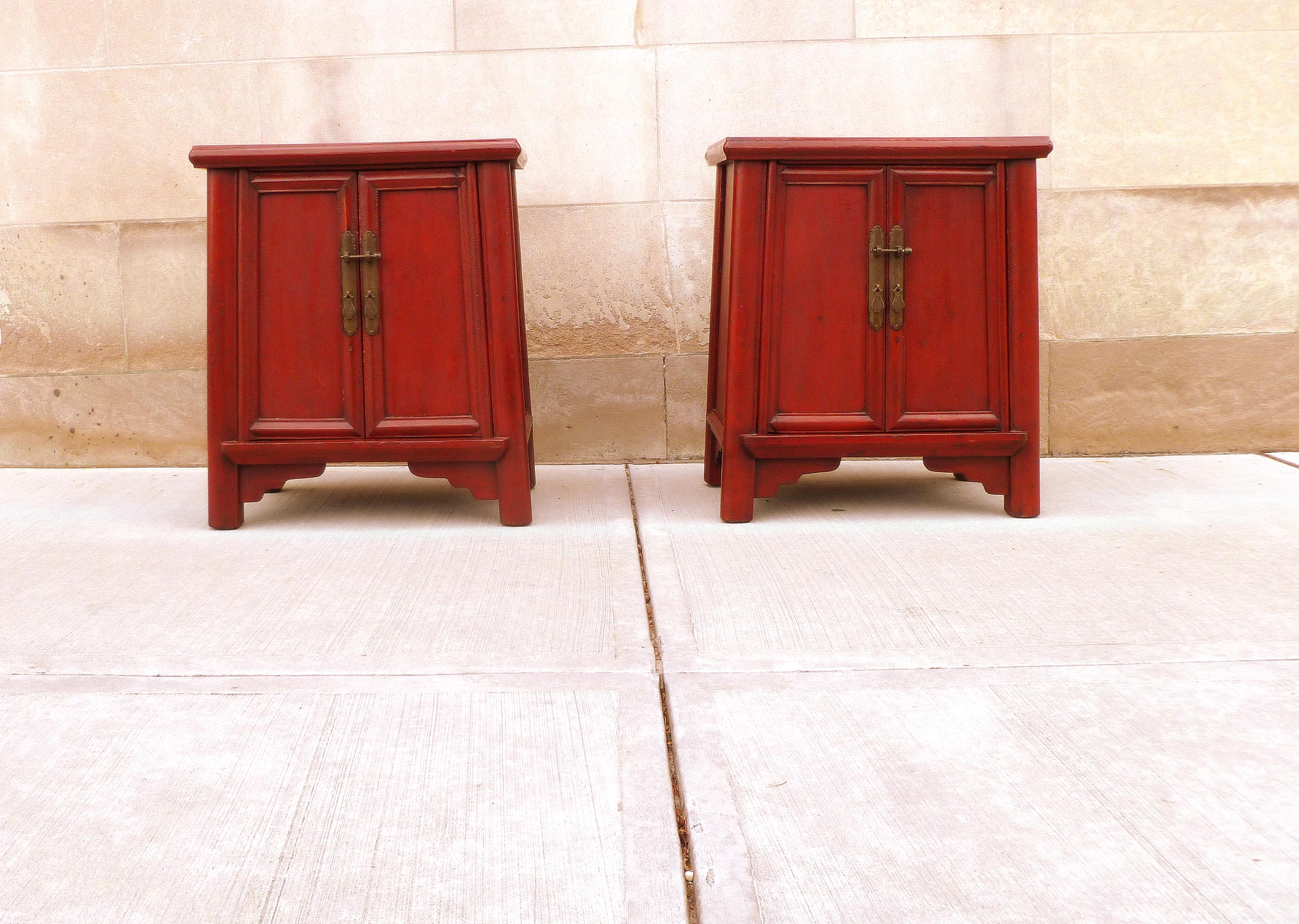 Paar rote Lacktruhen mit offenen Türen und herausnehmbarem Einlegeboden auf jeder Truhe, eine Schublade in jeder Truhe.