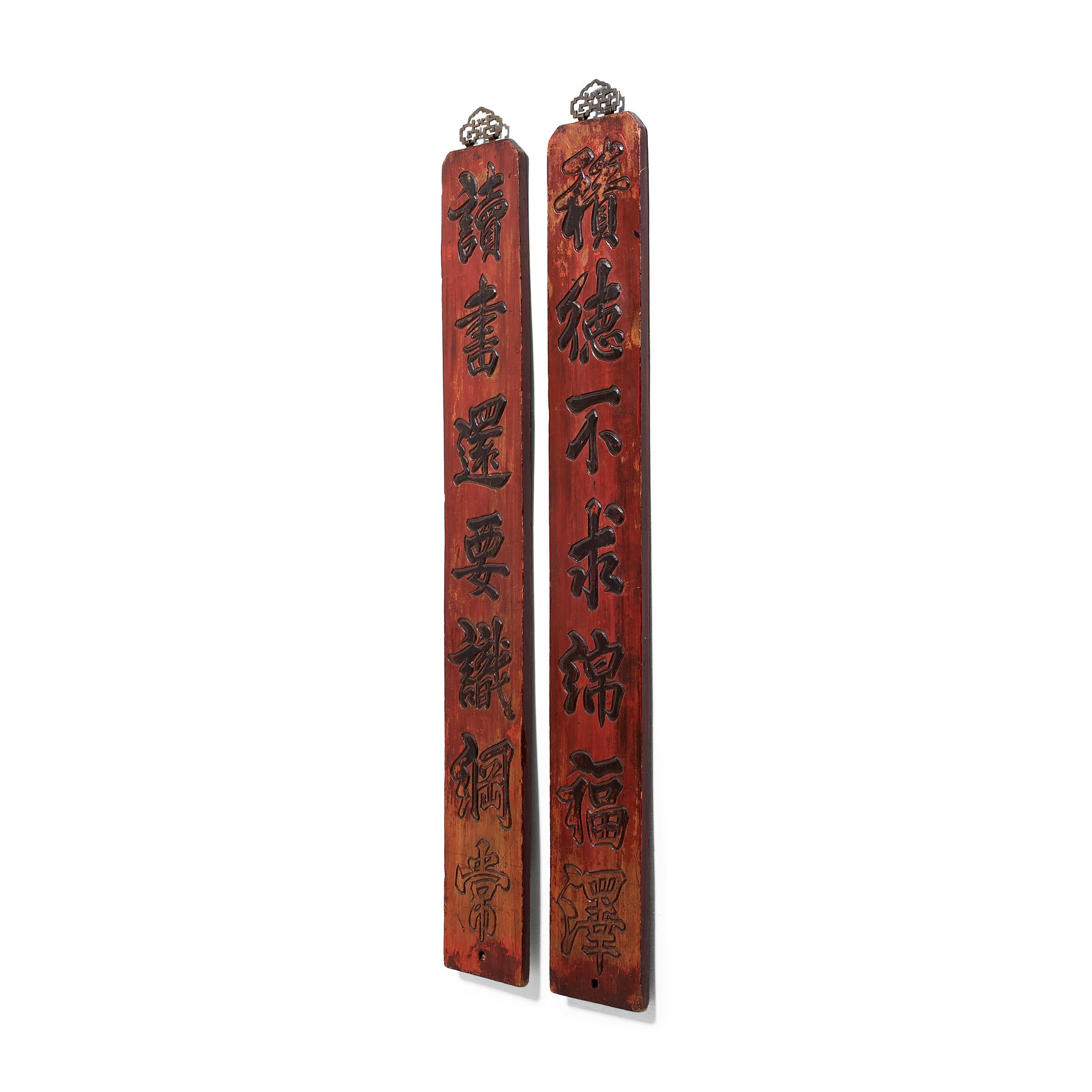 This pair of decorative red lacquer signs dates to the late 19th century and is carved in relief with a poetic couplet. Carved to resemble ink calligraphy, the couplet reads: 