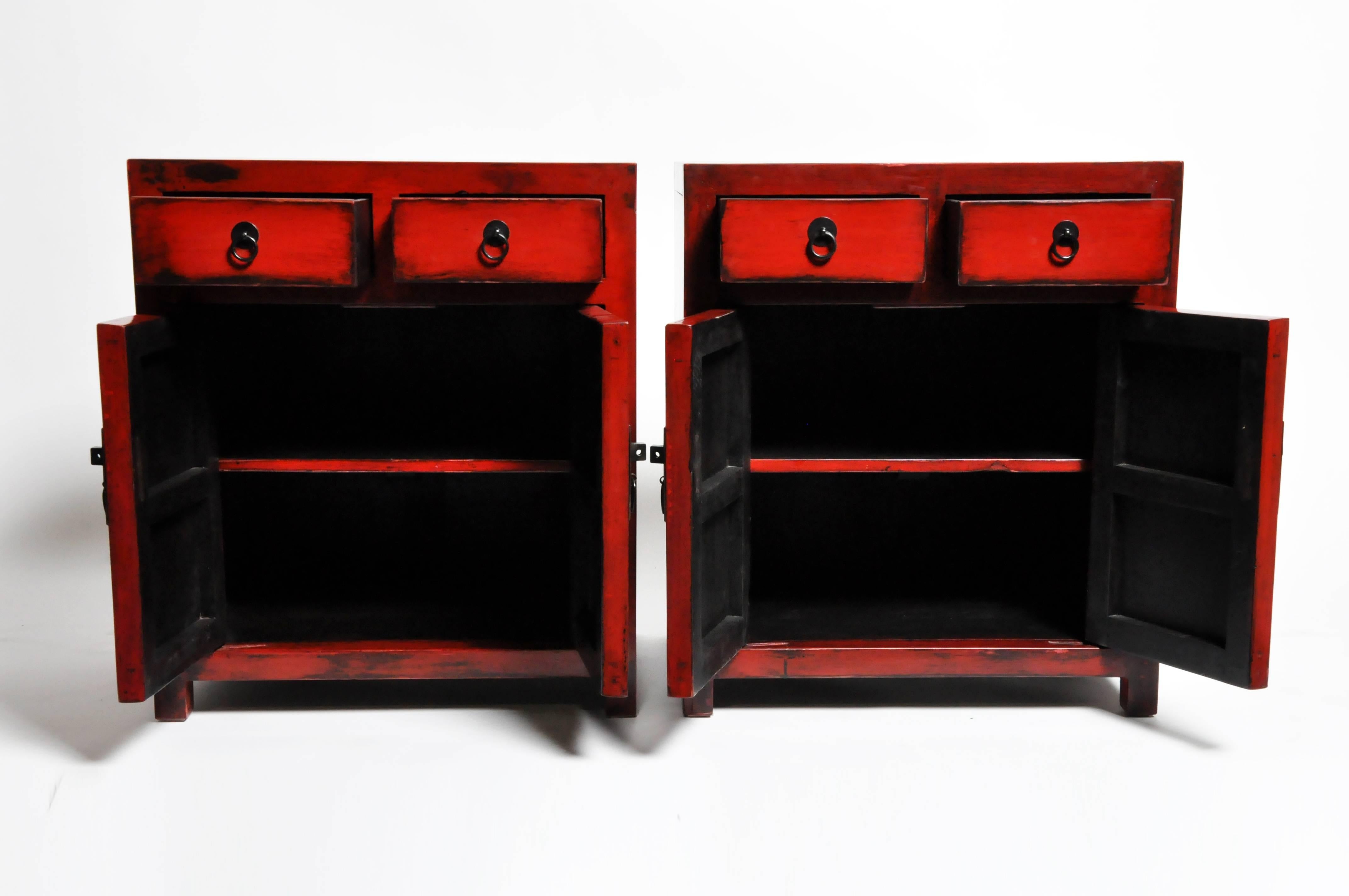 Add a pop of red to any room with this pair of red lacquered side chests from Zhejiang, China. Made from reclaimed elm wood and lacquer the pair features mortise and tenon joinery, two drawers, and a shelf each. You can also customize a new one and