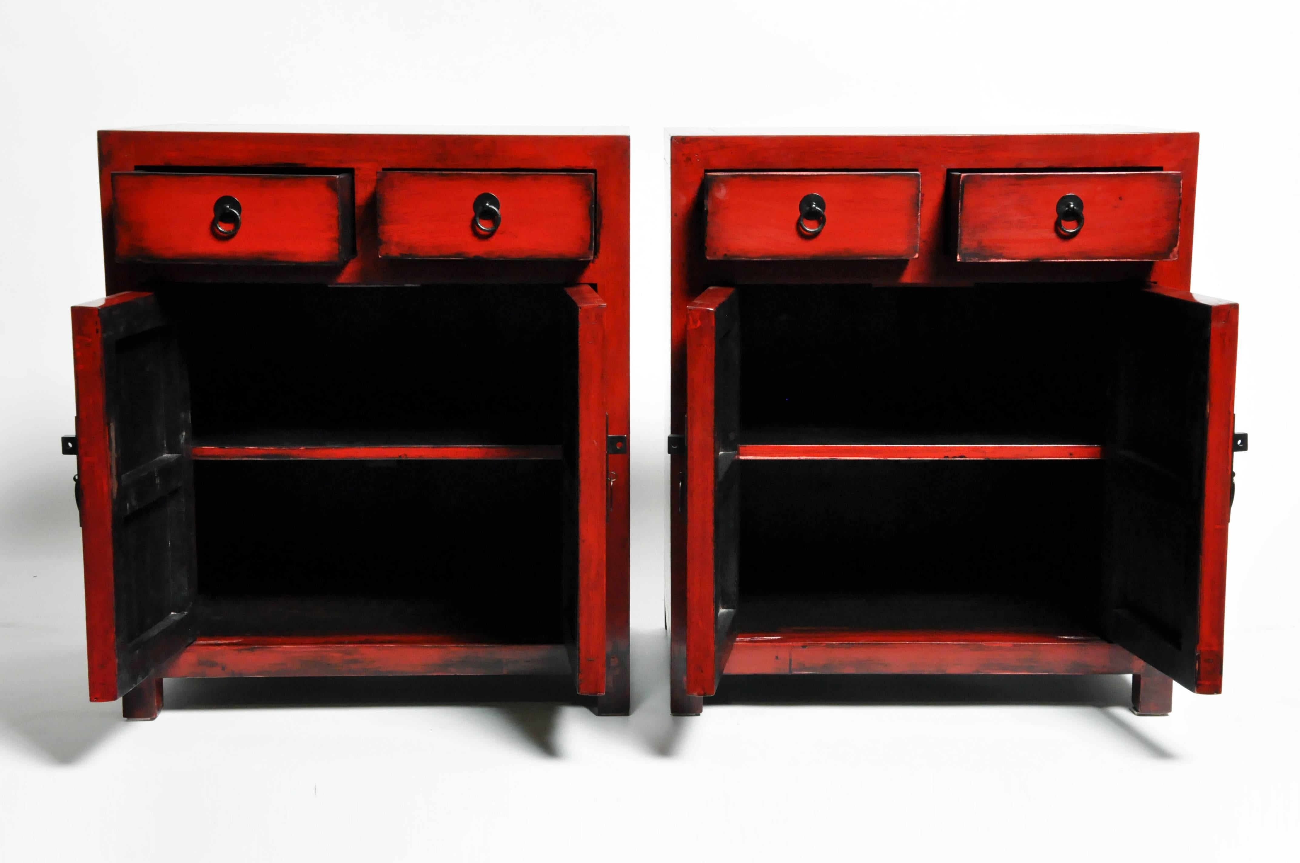 Add a pop of red to any room with this pair of red lacquered side chests from Ningbo, China. Made from reclaimed elm wood and lacquer the pair features mortise and tenon joinery, two drawers, and a shelf each. You can also customize a new one and