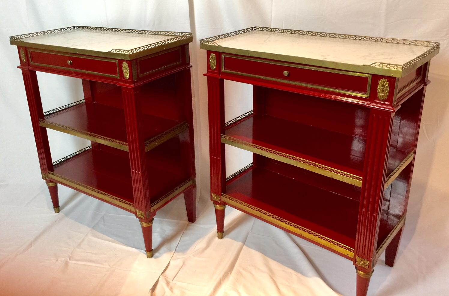 Exceptional and rare pair of lustrous red ebonized occasional tables. This three-tiered pair of side tables is made of ebonized wood with tôle and bronze hardware detail. The white marble top is edged by a pierced bronze gallery. The two lower tiers