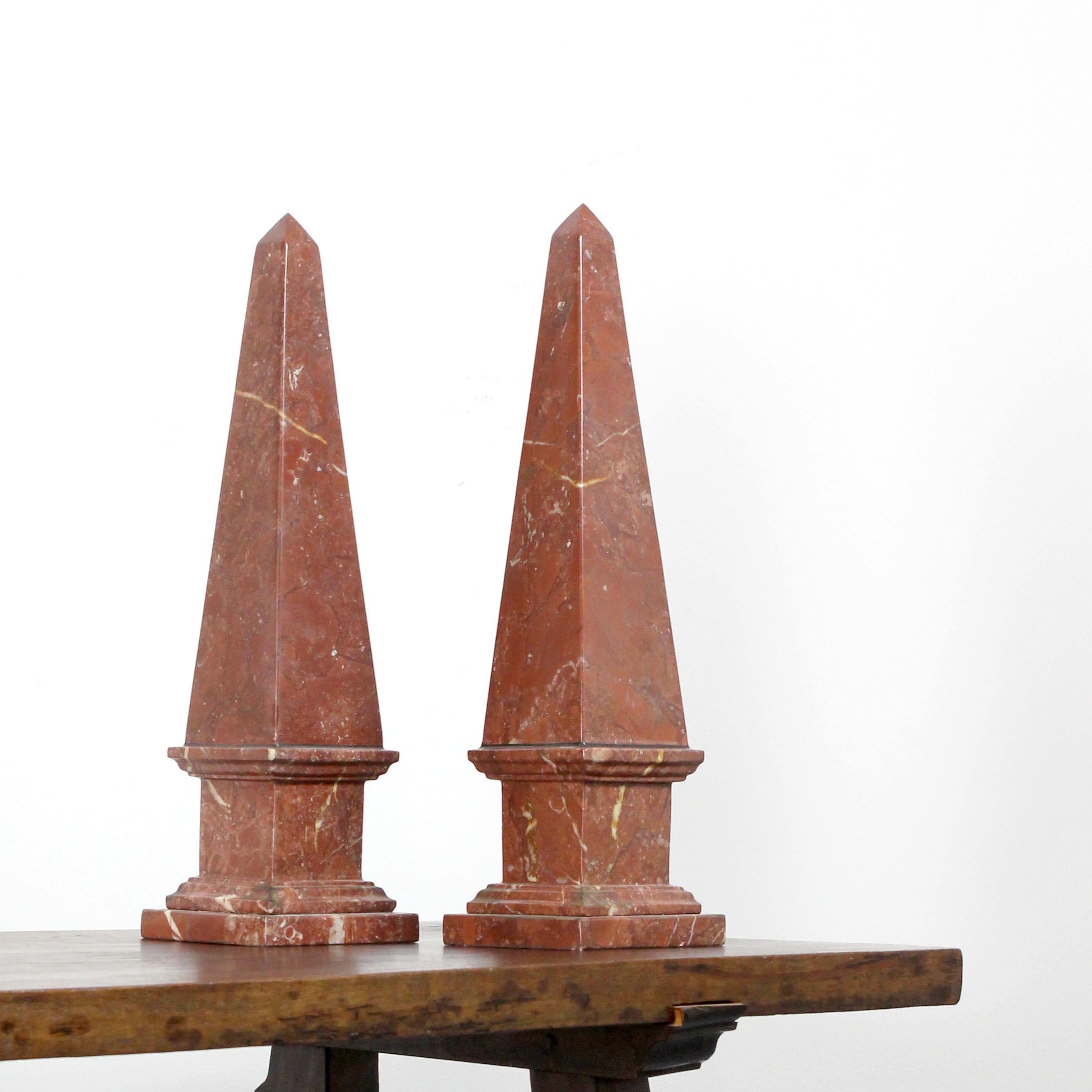 A pair of obelisks, crafted from red marble in Italy during the 19th century.