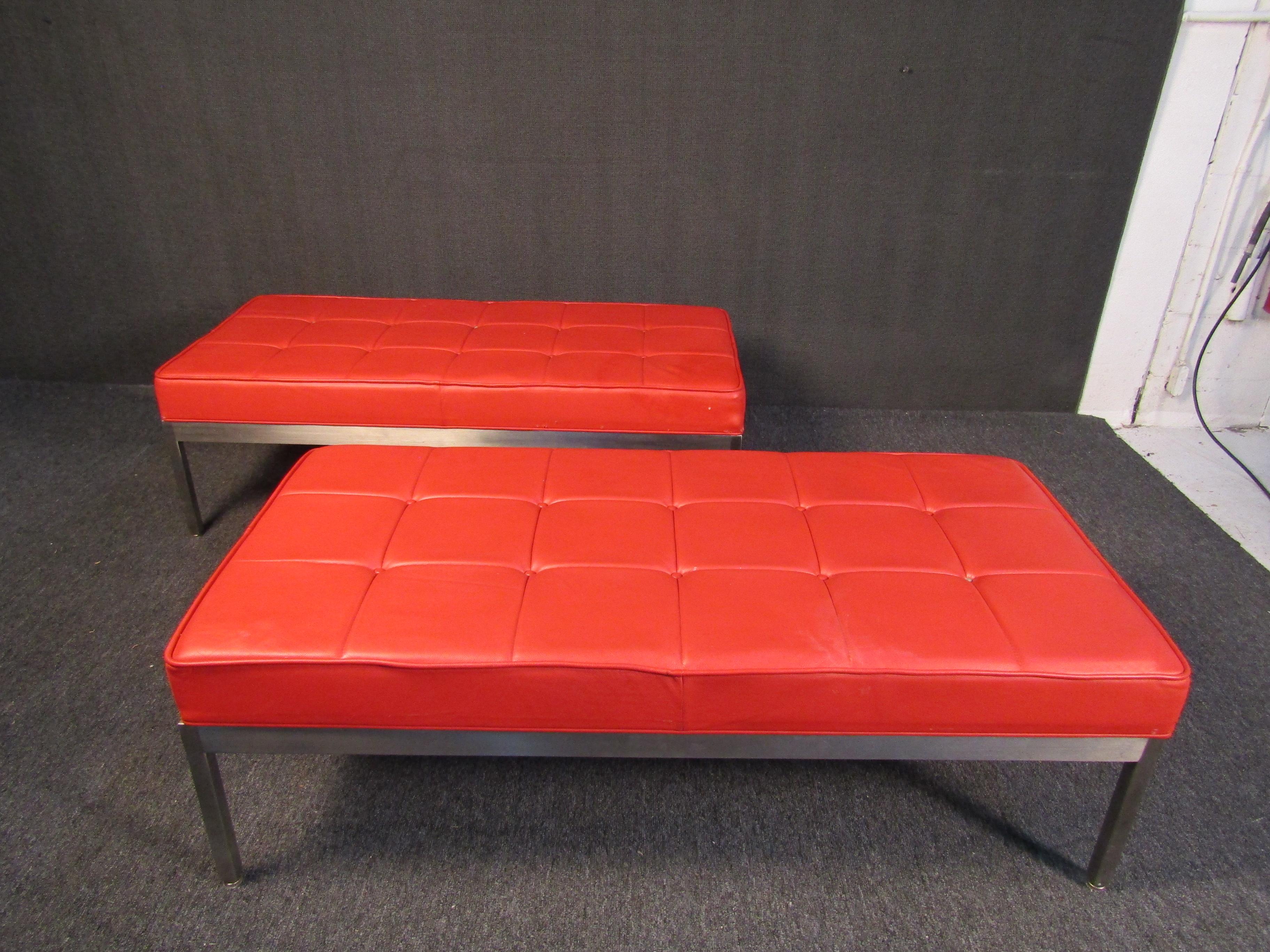 A pair of Mid-Century Modern ottomans in brilliant red upholstery and chrome. Featuring an elegant design and comfortable cushions, this pair is perfect for adding vintage style to a room. Please confirm item location with seller (NY/NJ).