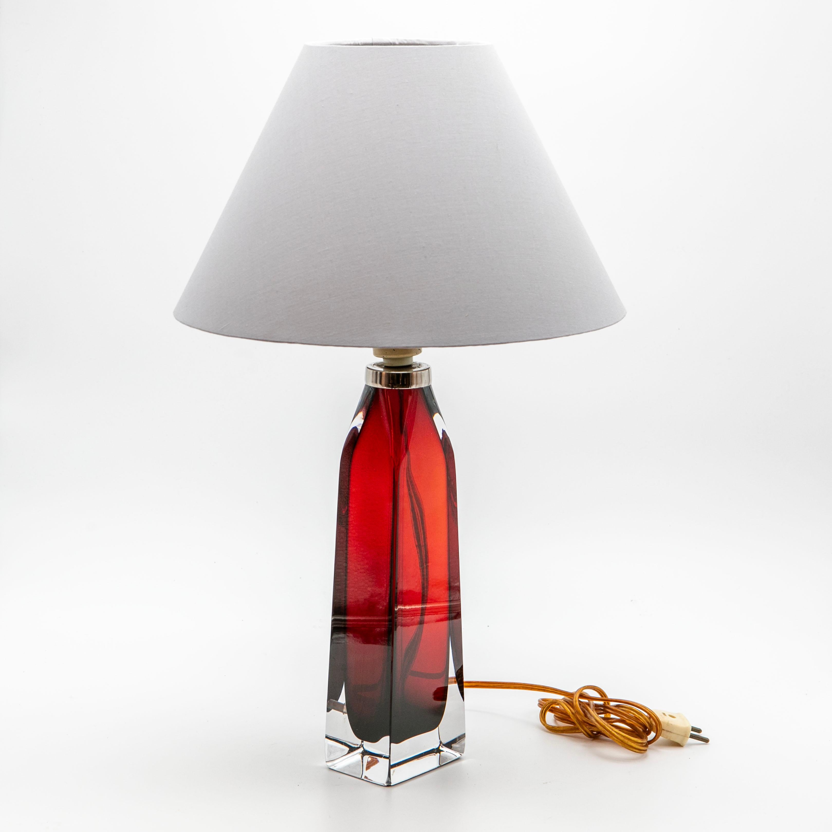A pair of table lamps designed by Carl Fagerlund for Orrefors around 1960.
The lamps are in red and clear glass, topped with a chrome-plated brass ring. 

Signed 'Orrefors' just below the chrome ring.

In original, perfect condition.
Only sold as a