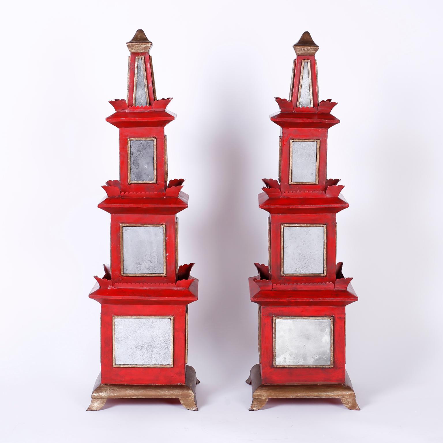 Dramatic pair of midcentury pagodas crafted with wood and metal painted red and decorated with distressed mirrors. The finials, bases, and mirror frames are distressed gold leaf. The large-scale and unusual mixture of materials make these a unique