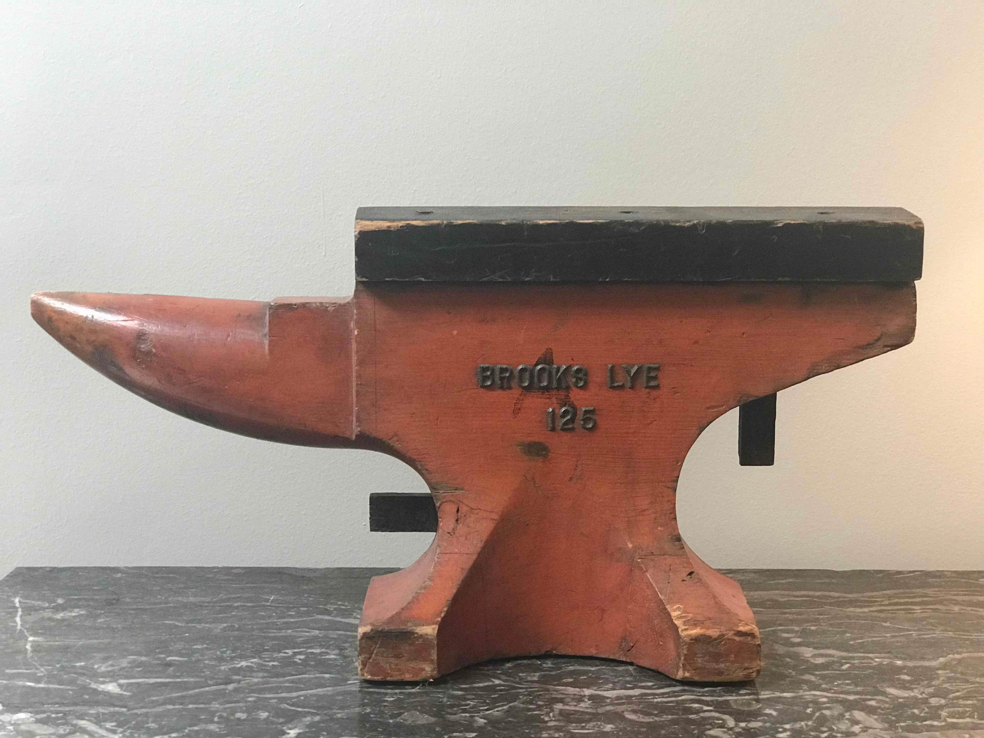 Pair of Brooks Lye red painted wooden anvil models from 1940s England. Now produced under the name Vaughn, John Brooks Lye LTD Blacksmiths was known for producing high quality cast steel anvils during WWII. With their sculptural shape vibrant color,