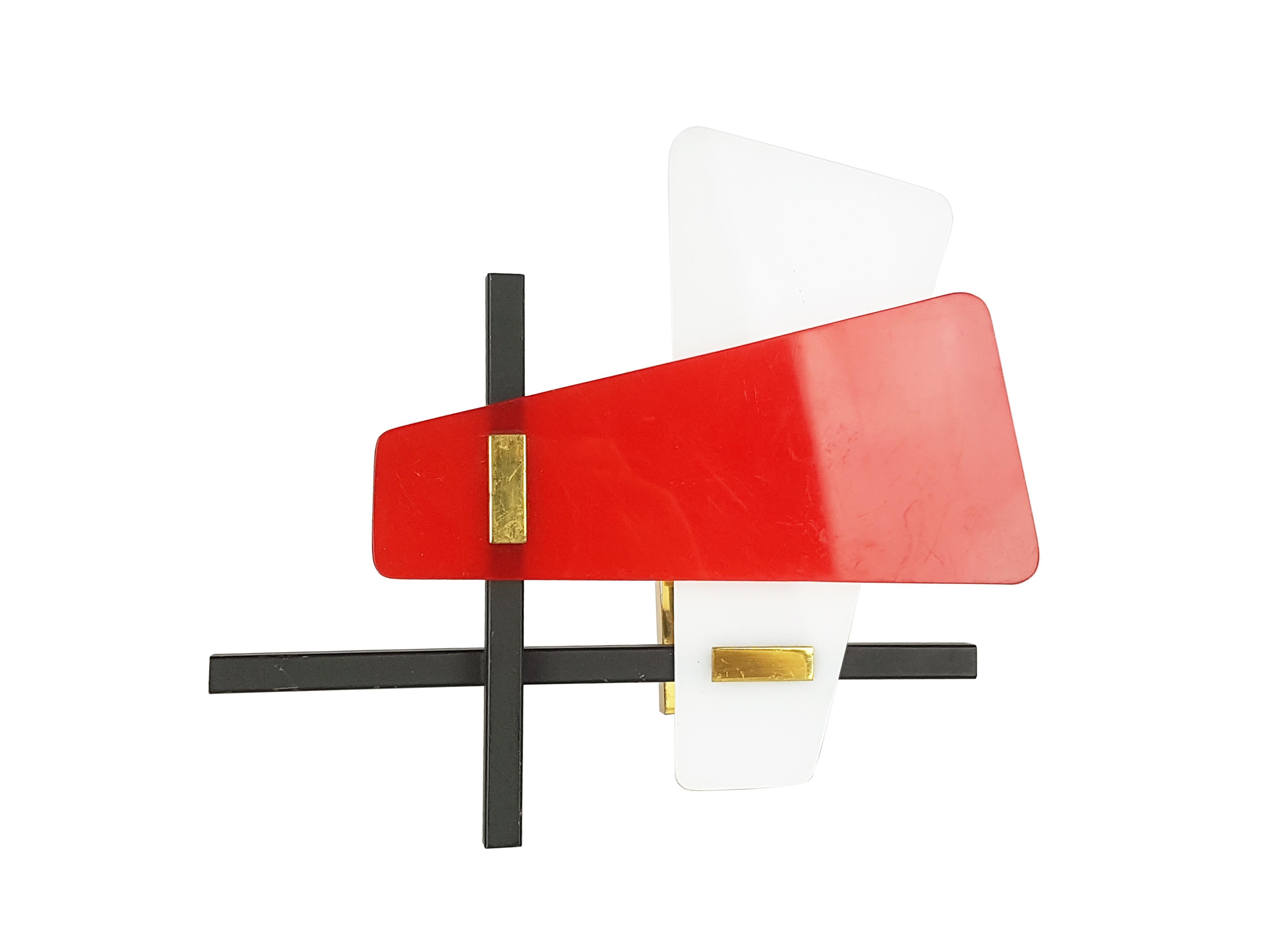 Pair of small wall lamps, produced in Italy around 1960. They are made from black painted metal and brass structure with red and white perspex shades. Equipped with an E14 socket lamp.
Brand new condition: the lamps have been never used, but show