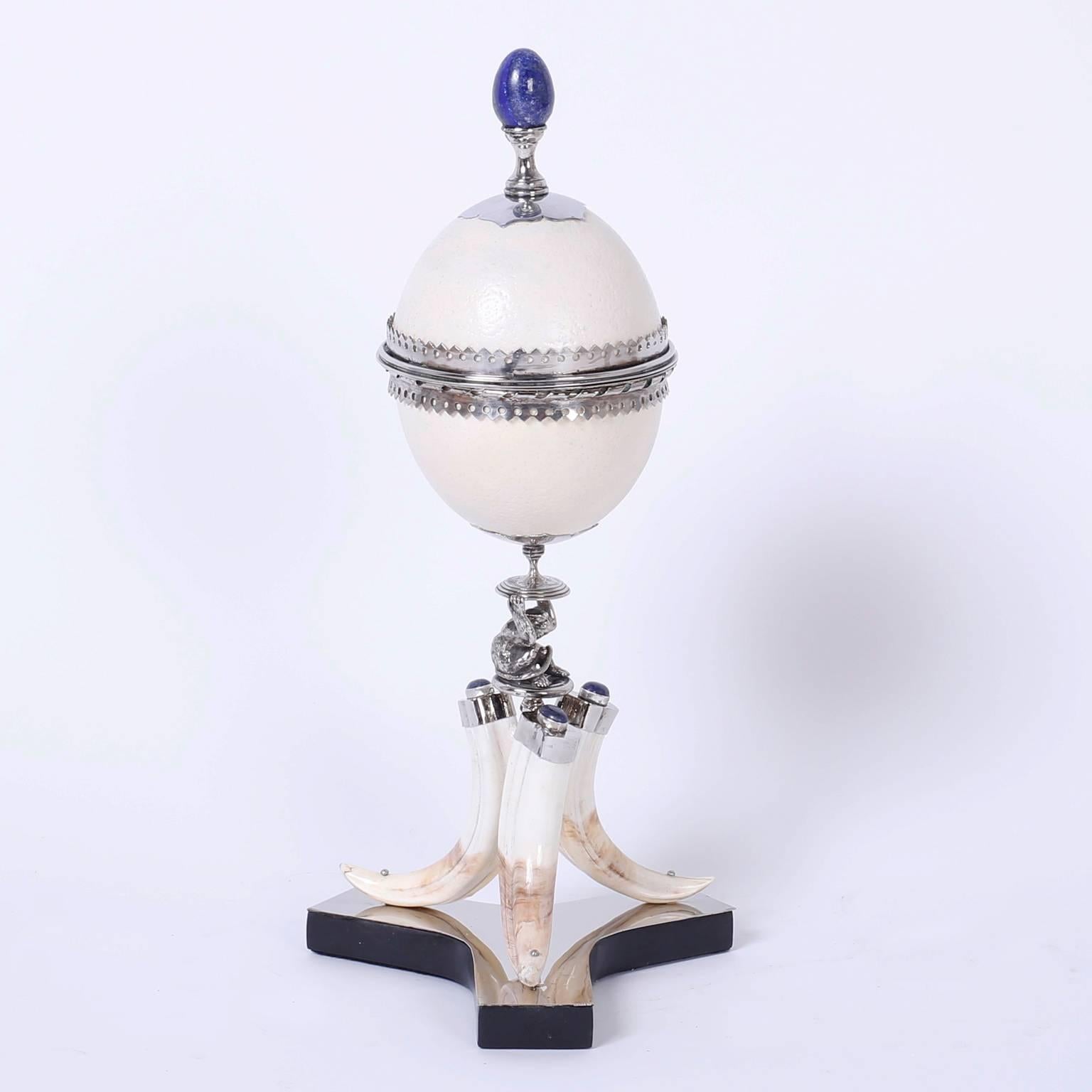 Fine and rare pair of Redmile garnitures featuring lapis lazuli finials on ostrich egg boxes carefully supported by seated silver plated monkeys on three boar tusk bases. For the discriminating collector of luxurious decorative arts. Signed Redmile