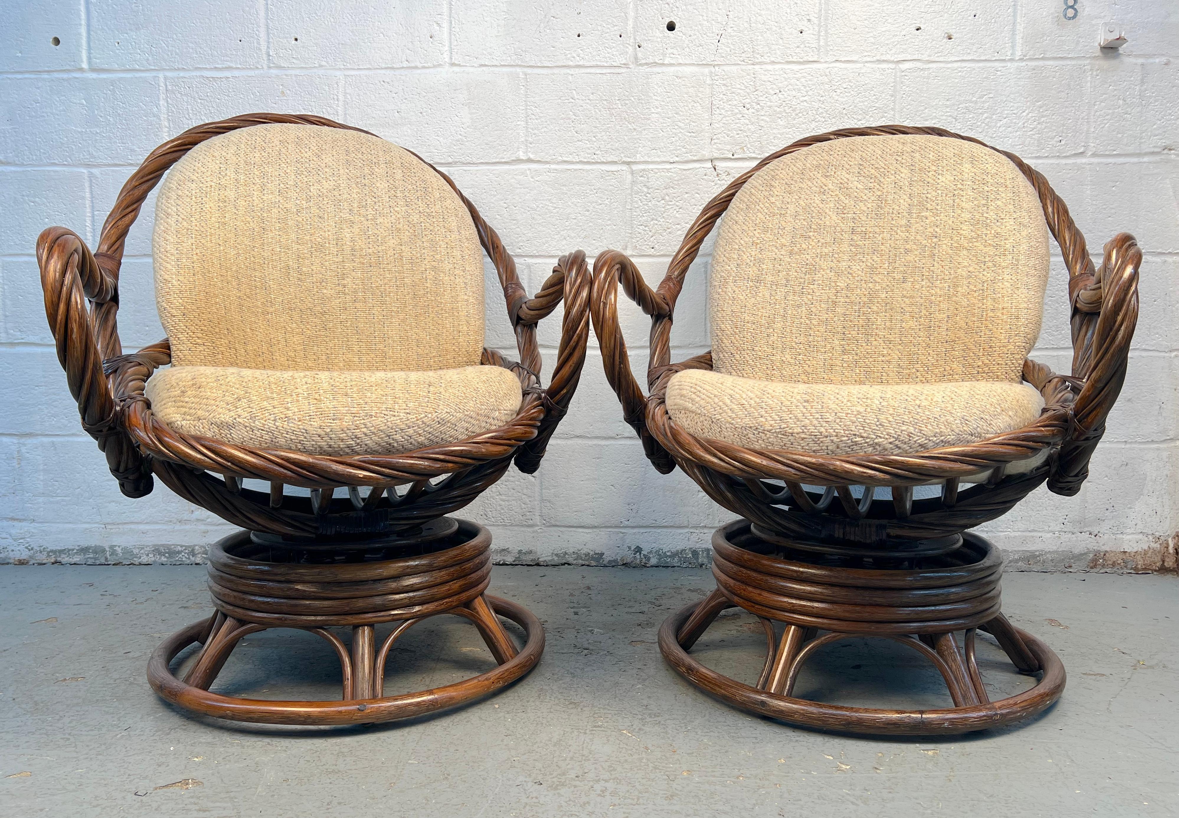 Questa elegante coppia di sedie girevoli degli anni '70 è caratterizzata da una particolare struttura in canne e bambù, che combina una texture naturale con un tocco di modernità di metà secolo. Le loro sedute dolcemente curve e le basi girevoli
