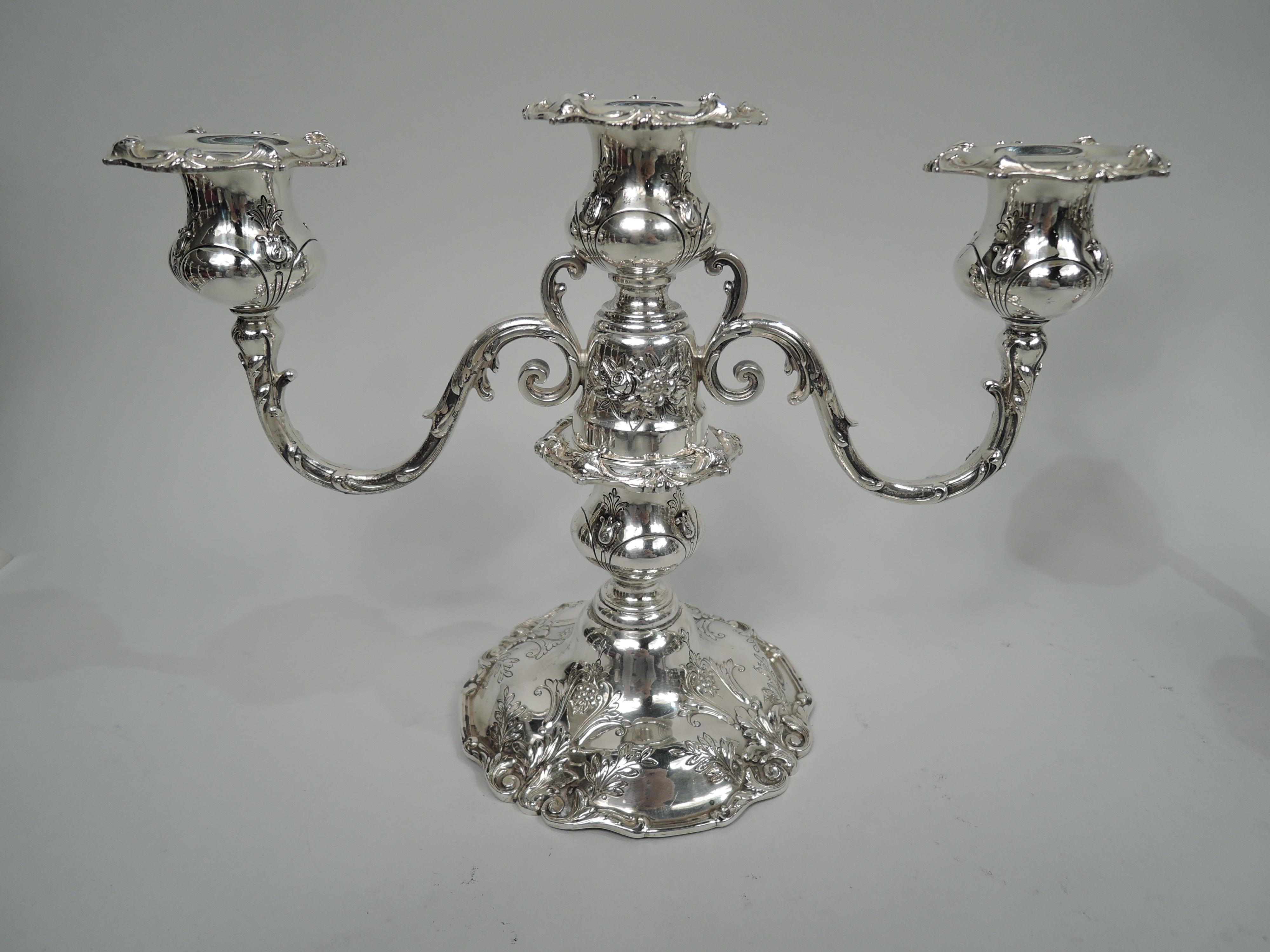 Pair of Francis I sterling silver low 3-light candelabra. Made by Reed & Barton in Taunton, Mass. in 1950. Each: Central socket on bell-form base to which are mounted 2 split-mounted and leaf-wrapped arms, each terminating in single socket. Shaft