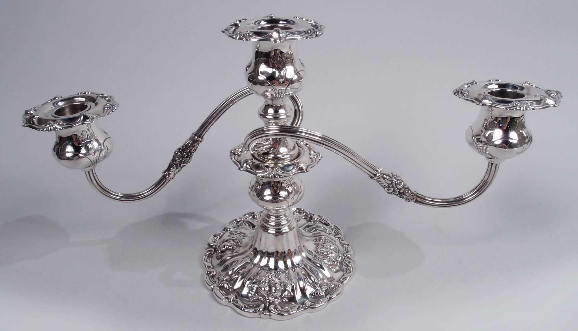 Pair of Francis I sterling silver low 3-light candelabra. Made by Reed & Barton in Taunton, Mass. Each: Central socket on bell-form base to which are mounted two leaf- and flower-wrapped scrolled and reeded arms, each terminating in single socket.
