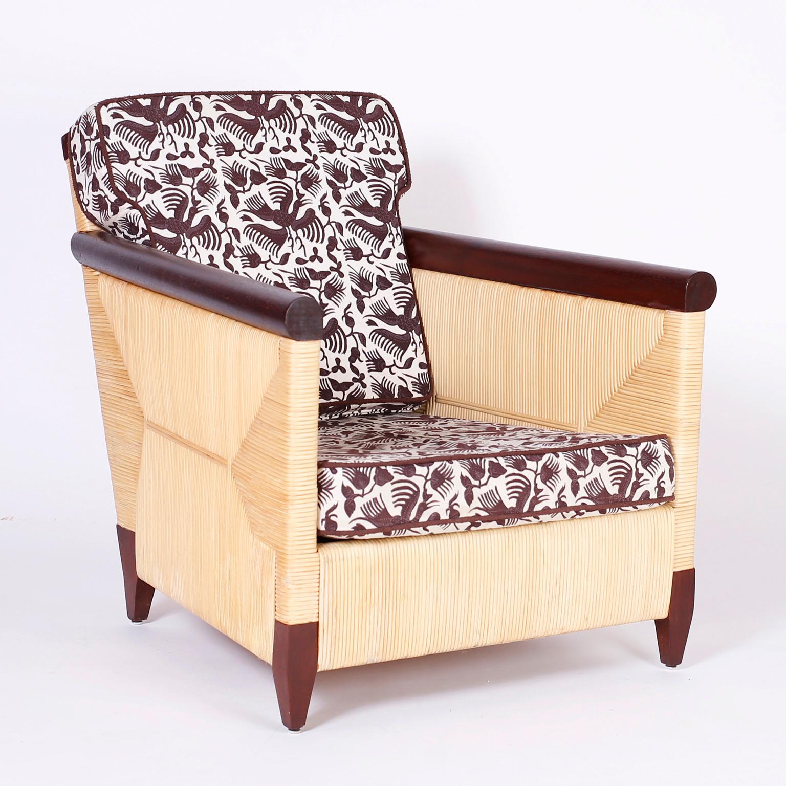 Pair of Donghia lounge chairs designed by John Hutton with a sleek modern interpretation of a British Colonial chair featuring a reed wrapped frame highlighted by mahogany arms and feet. Signed Donghia at the bottom.