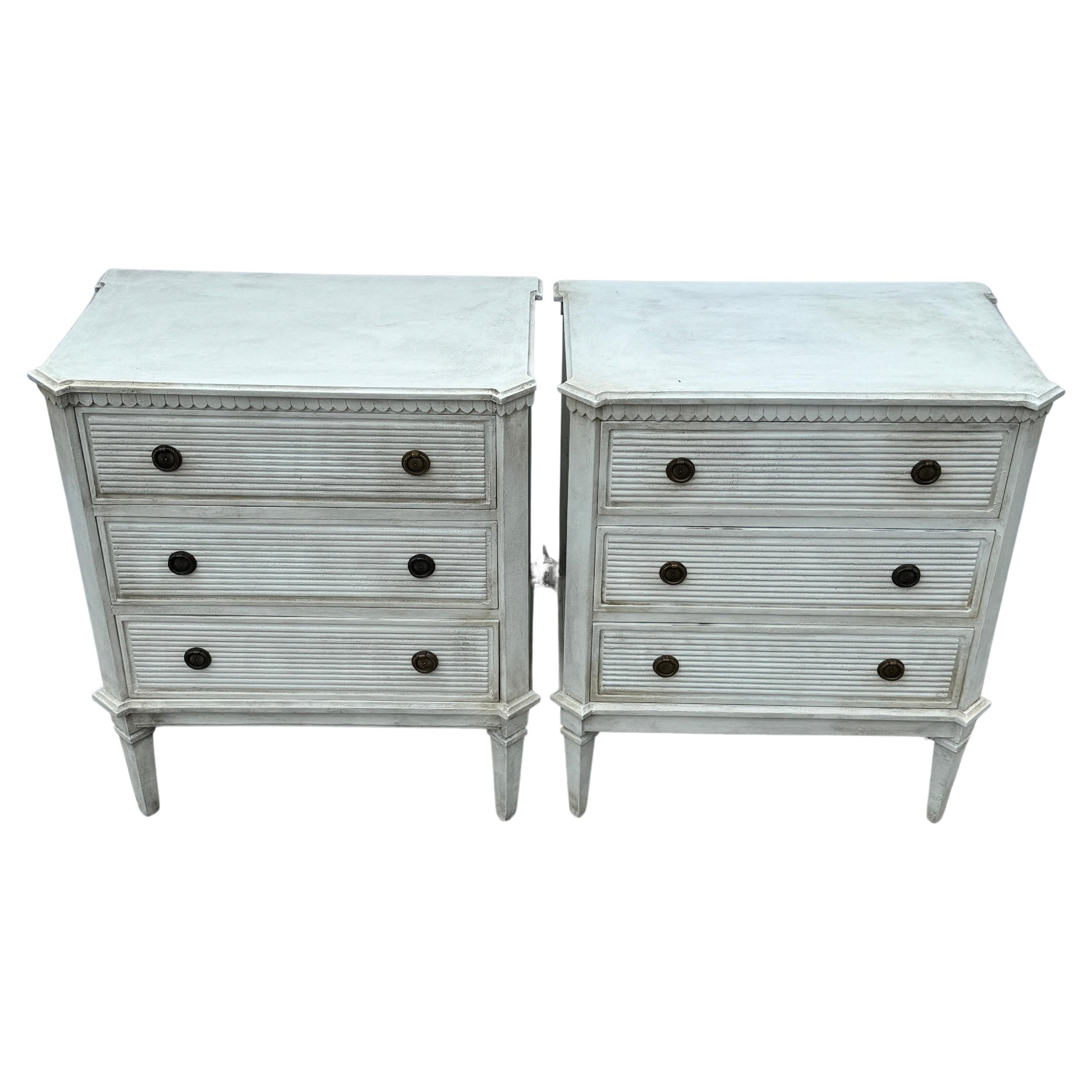 White Painted Gustavian Style Chest of Drawers, A Pair  

Pair of white/greyish hand painted Gustavian style chest of drawers constructed from solid wood with a hand-applied distressed finish with brass ring hardware. These classic Swedish style two