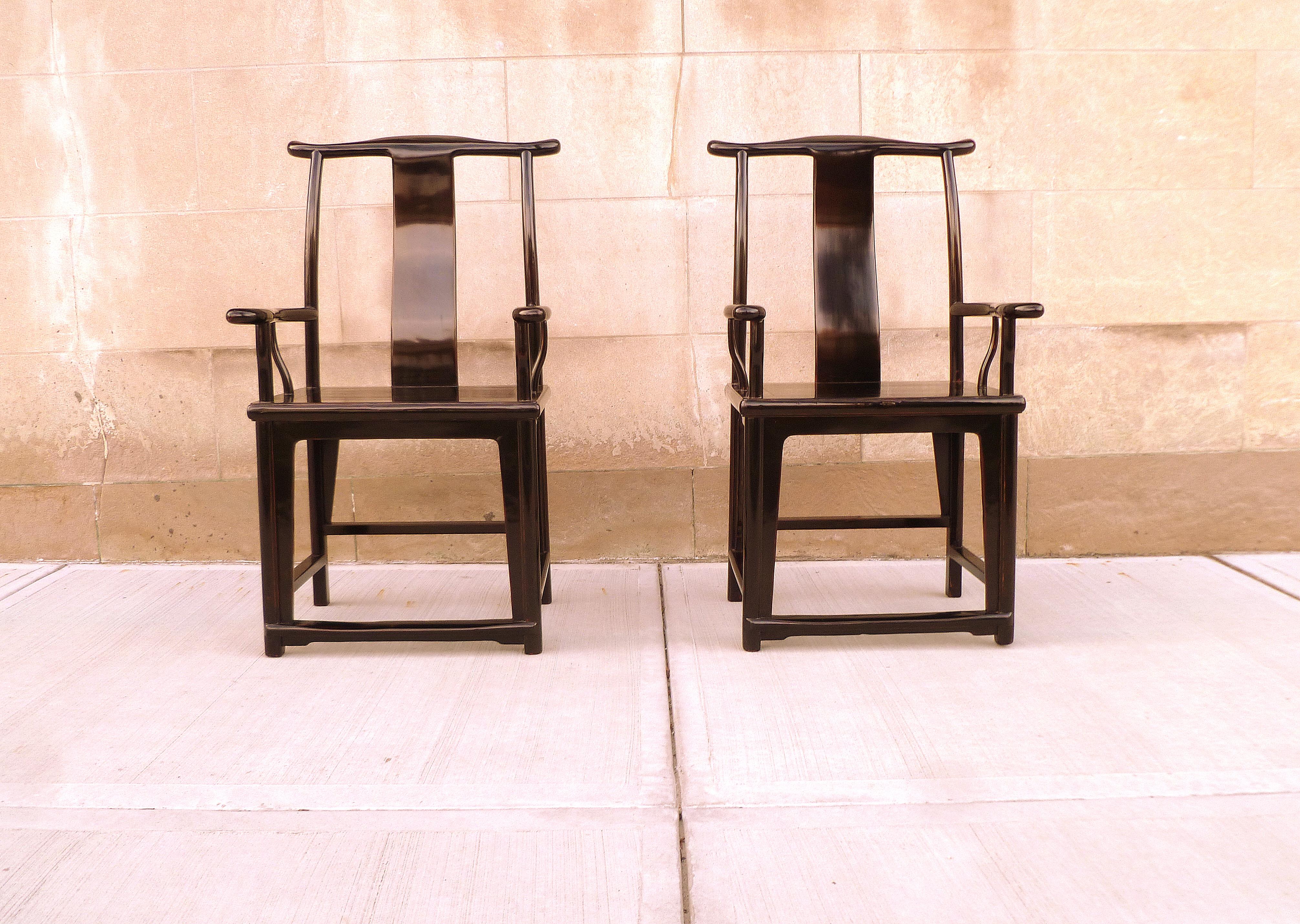 A pair of refined black lacquer yoke back armchairs. Beautiful color, form and lines. We carry fine quality furniture with elegant finished and has been appeared many times in 