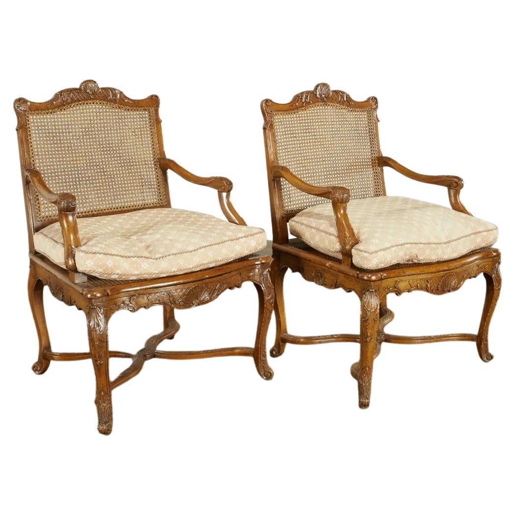 Pair antique Regence style beechwood fauteuils, 18th/19th c., with carved shells and acanthus leaves to frames, caned back and seat with loose cushion, unmarked, 38