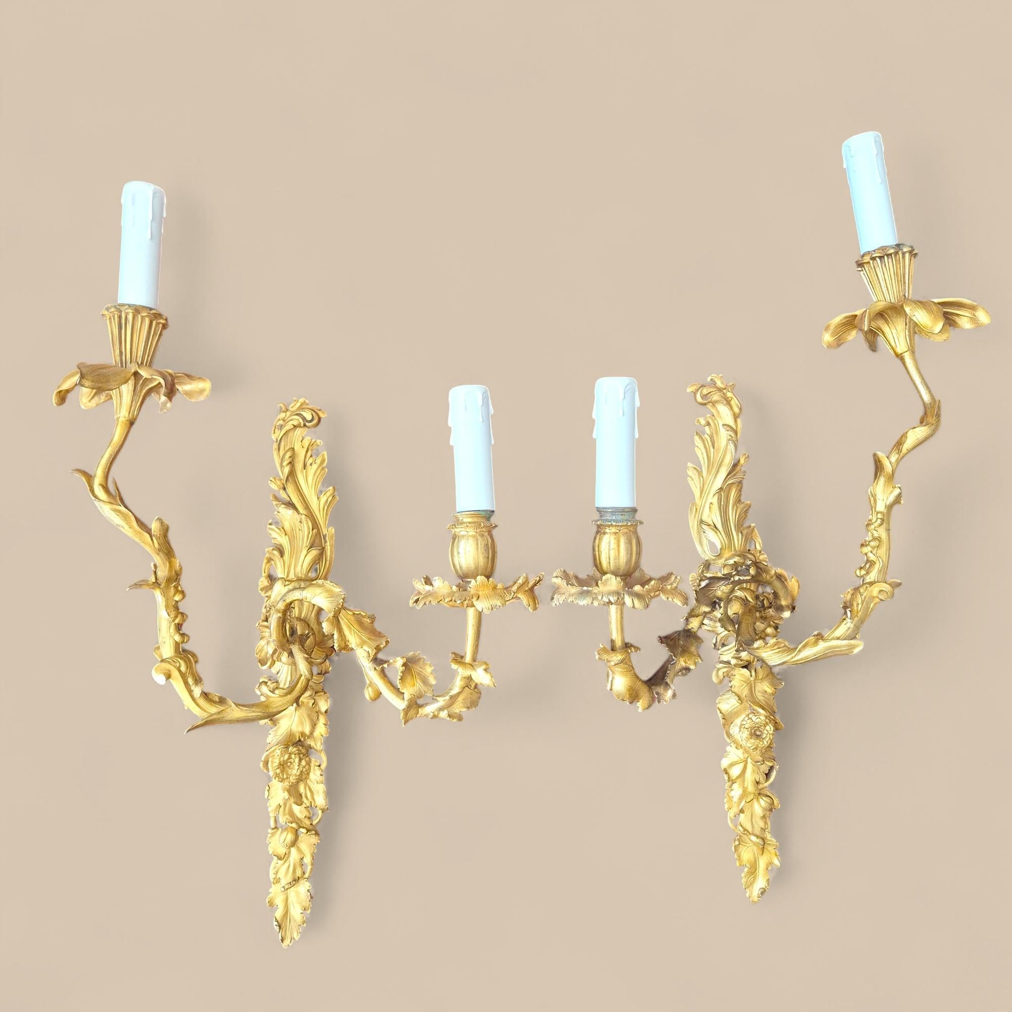 Pair of two-light wall sconces that perfectly illustrate the refined taste of the Second Empire for the sumptuous reinterpretations of 18th-century styles. Crafted in gilt bronze, they feature a very finely chiseled decoration of flowers and