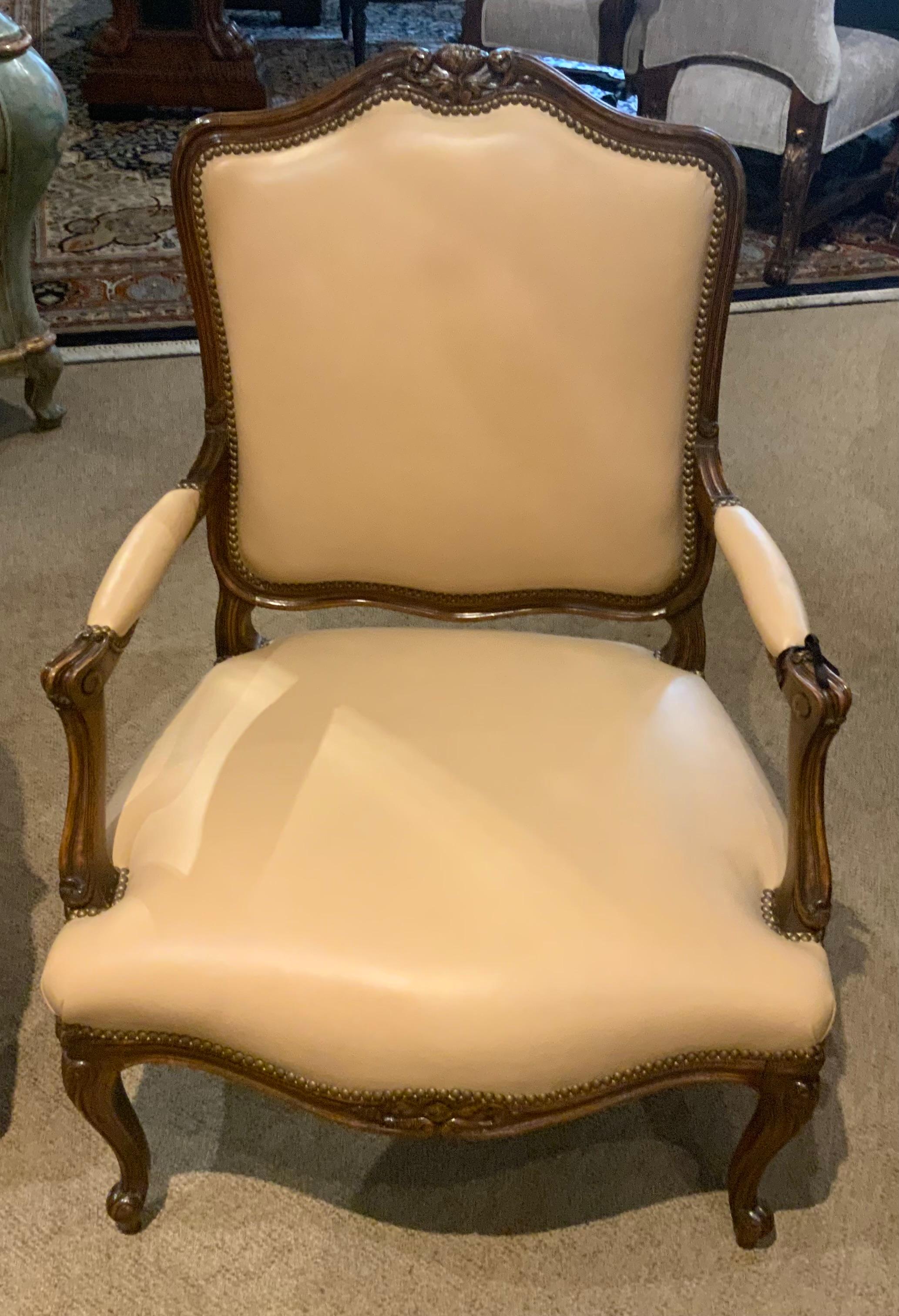 Rivestimento in pelle pregiata color crema con rifiniture in chiodo
Le teste adornano queste belle sedie. La cornice è in noce 
In stile Luigi XV con gambe cabriole ricurve. Il retro
È rivestita in un tessuto a quadri tonale.
