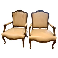 Pair of Regence Style walnut open armchairs in cream upholstery
