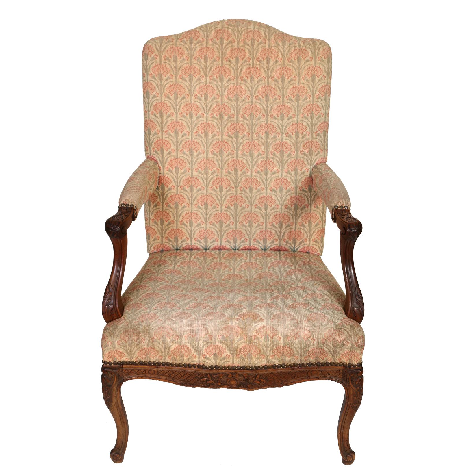 A pair of Regence style carved walnut upholstered fauteuil chairs with a pink carnation petit point tapestry upholstery to front and seat with nail head trim. Beautiful carved arms and cabriole legs