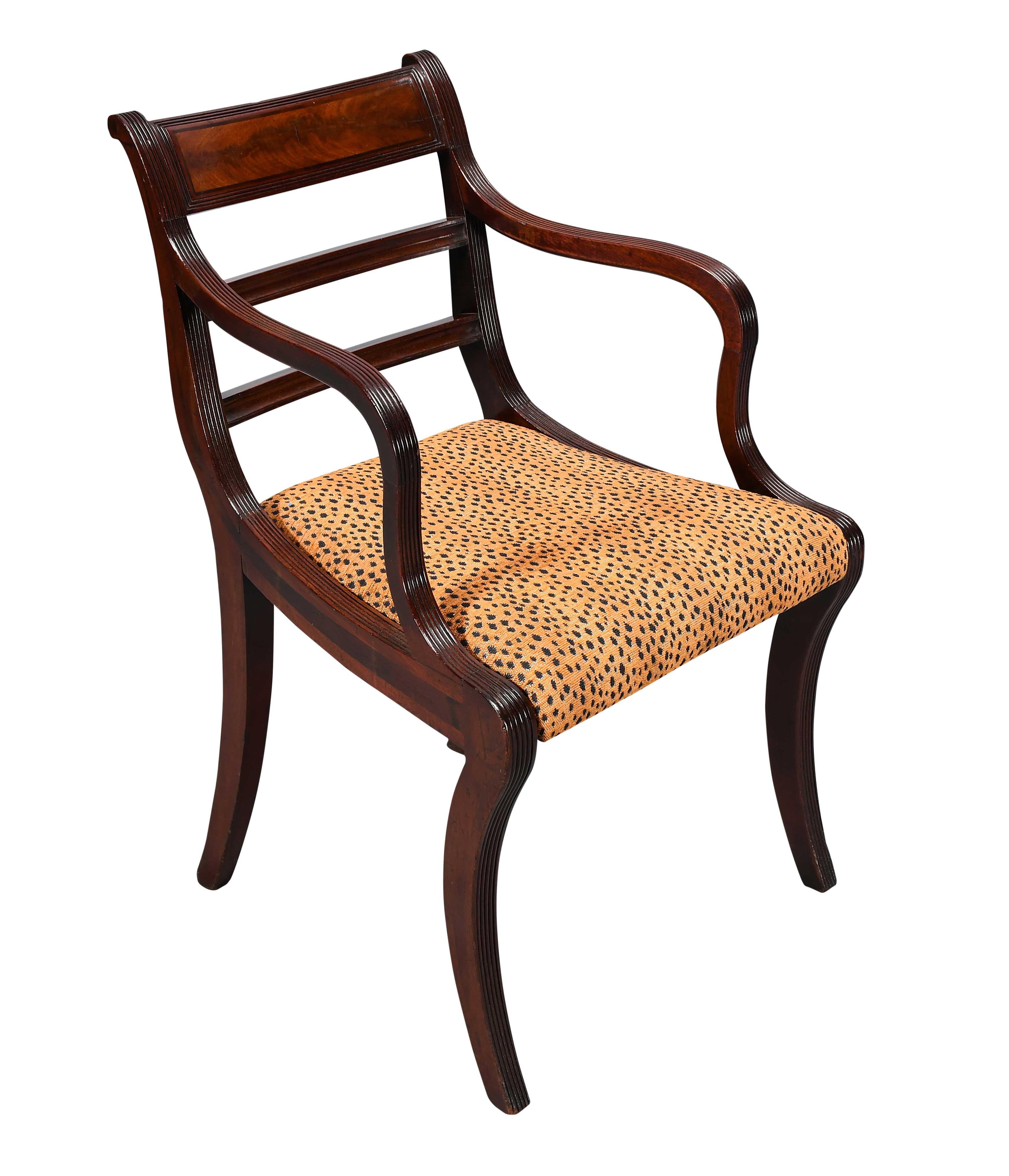 Paire de fauteuils en acajou d'époque Régence, à la manière de James Woodhouse, apprenti de George et Richard Gillow. L'ornementation des bras en forme d'ondulation se poursuit tout au long des jambes du sabre. Avec des détails ébonisés sur les