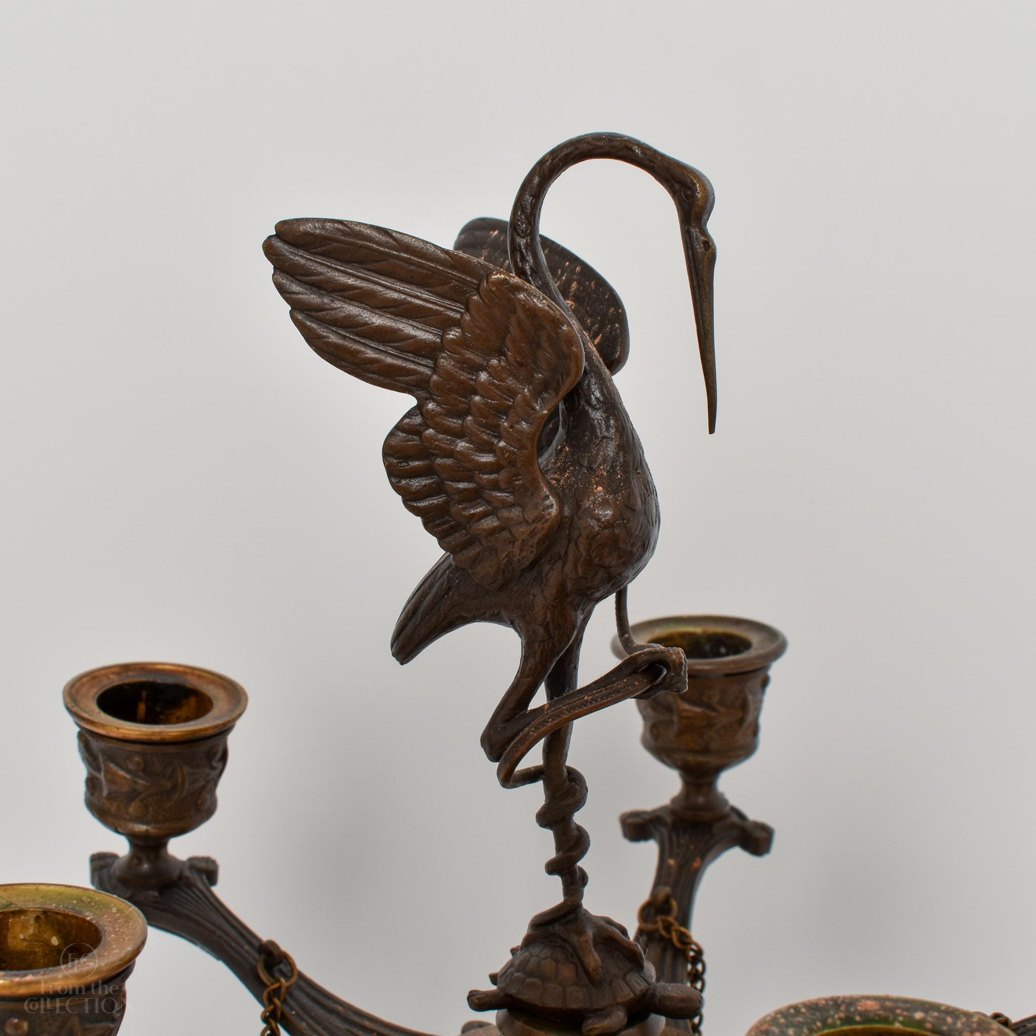 Pair of beautiful bronze regency crane candelabras circa 1820. The crane atop the pair is wonderfully detailed. There are feet for them to stand. A magnificent pair. These are beautifully decorated candelabra that would enhance a period or