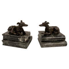 Paire de figurines de marionnettes couchées en bronze de style Régence sur socle en marbre vert