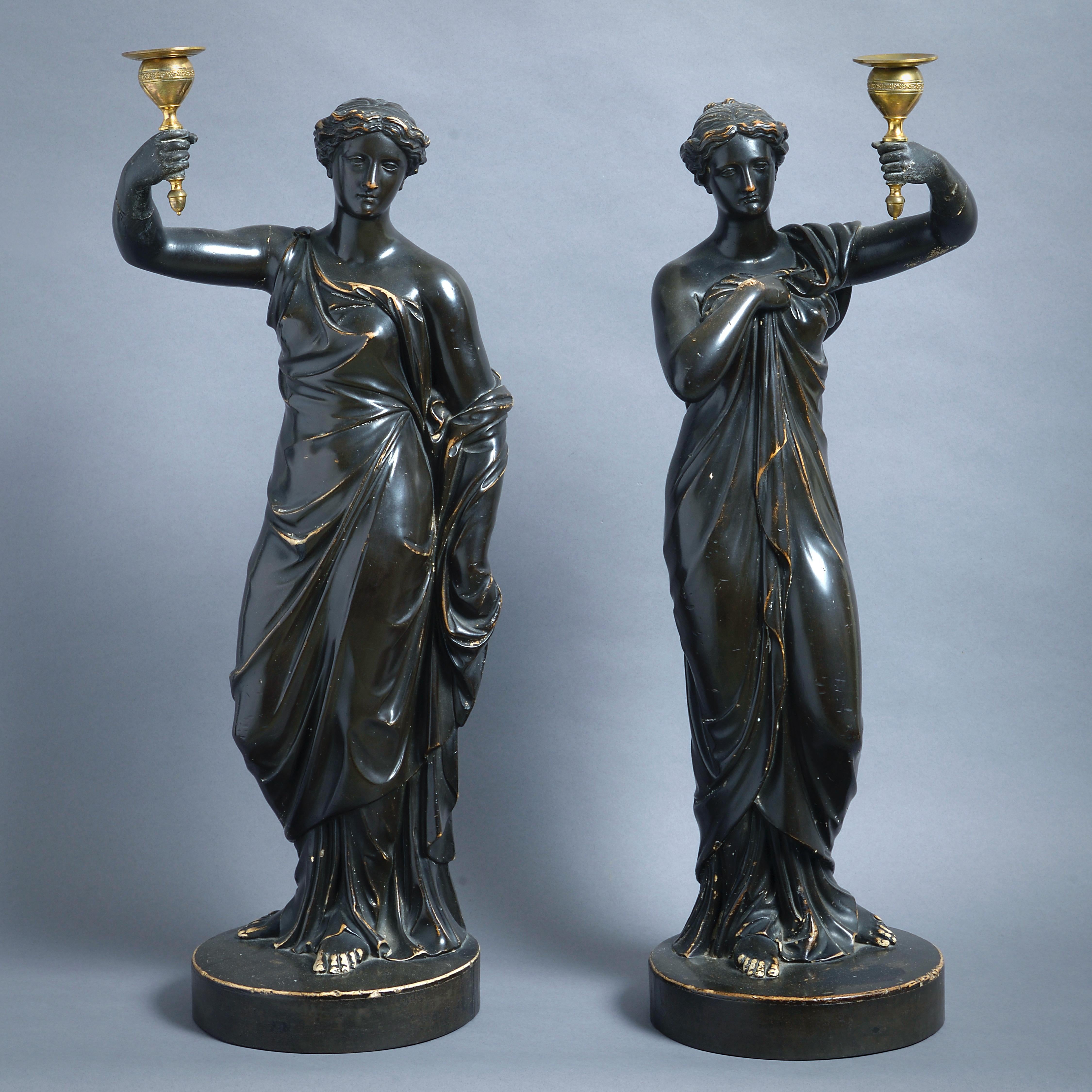 A FINE PAIR OF REGENCY BRONZED PLASTER FIGURAL CANDLESTICKS BY HUMPHREY HOPPER (1767-1844), CIRCA 1816.

Each in the form of a standing vestal bearing a lacquered brass candle-holder. Each signed H Hopper Lond. Jan. 1. 1816.