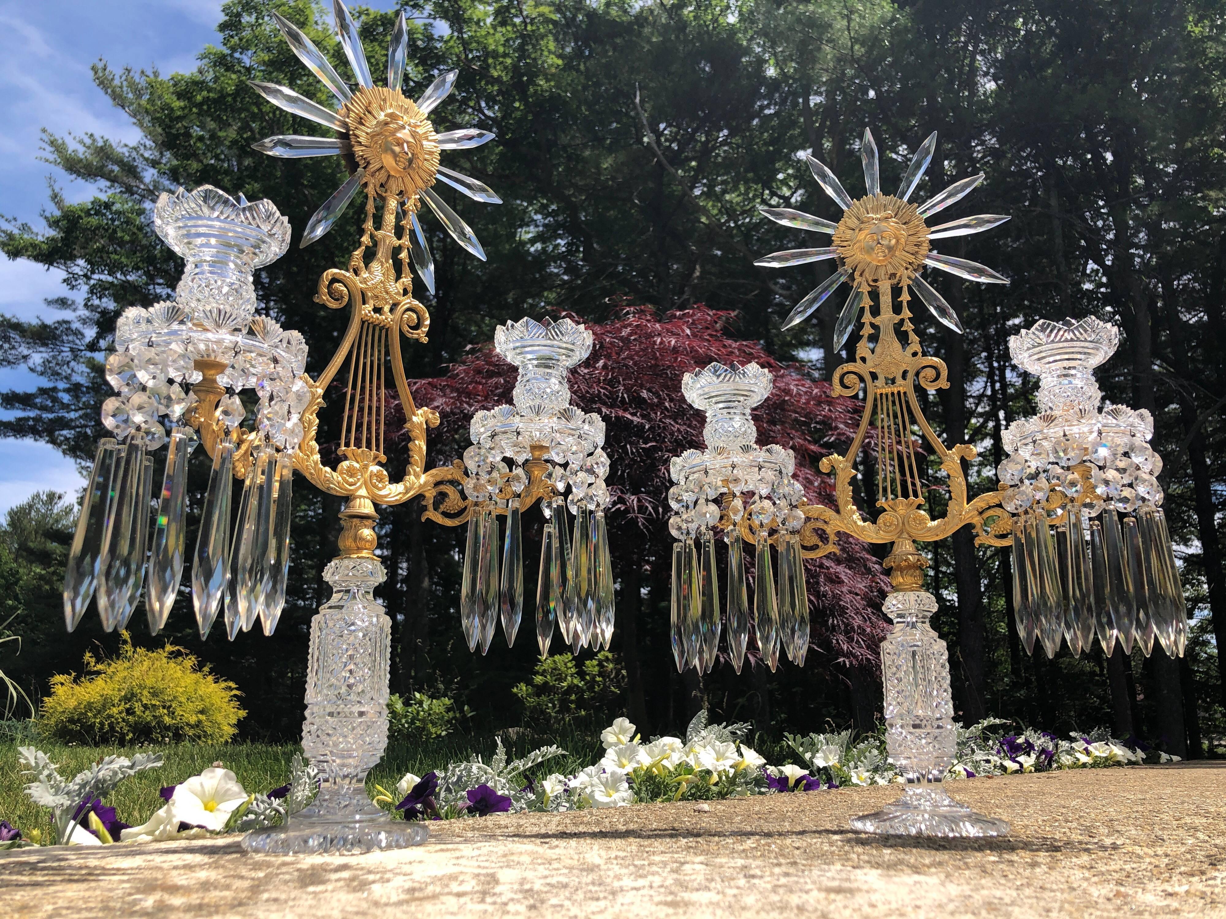 A very fine pair of English Regency Period two-arm candelabra, from a prominent family in Philadelphia, circa 1820. 
All aspects of the crystal are hand-cut in amazing detail. The circular, double sided, marquis cut crystals hanging from the candle