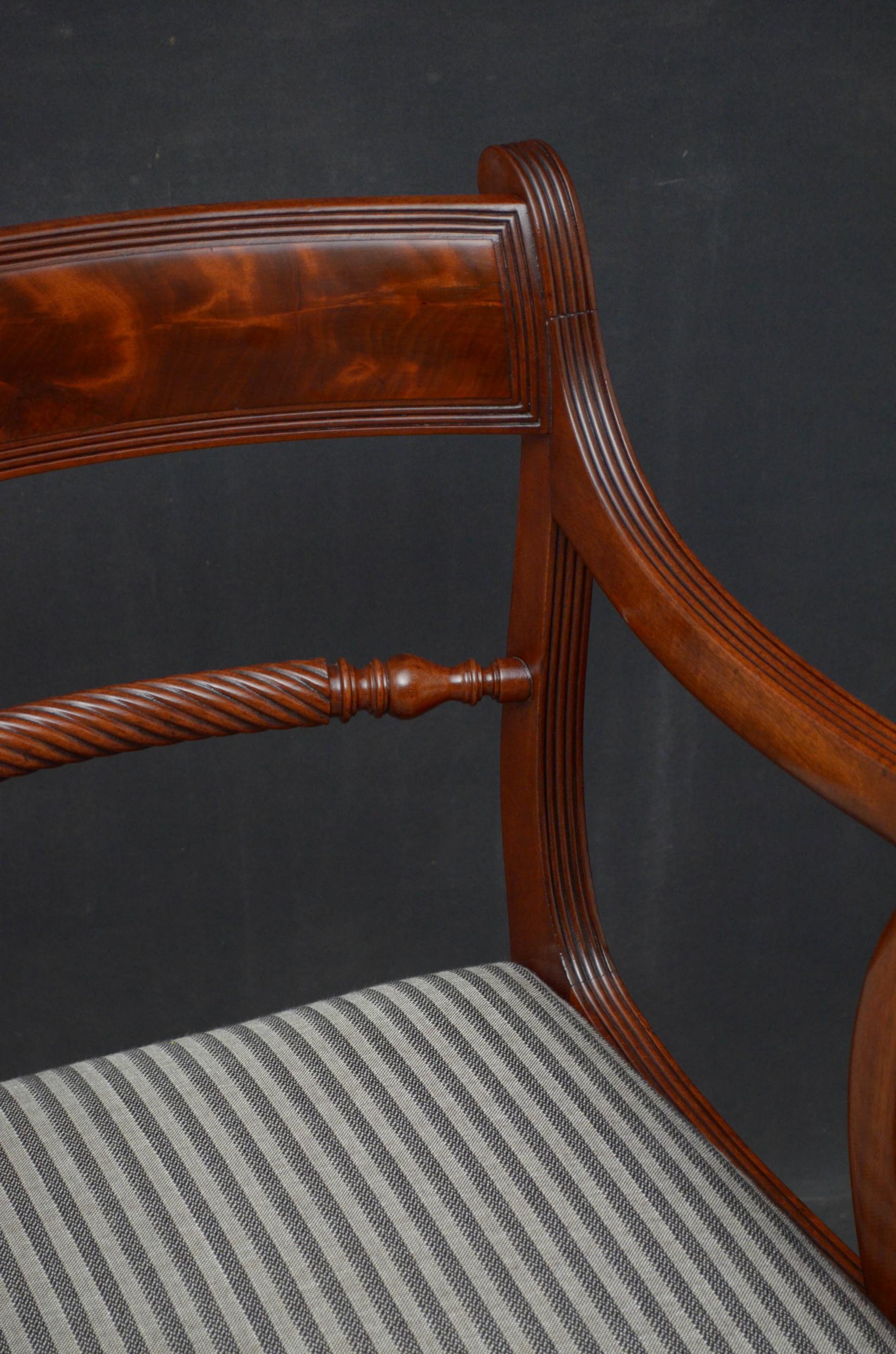 Sn5098 Fine quality Regency carvers, each having flamed mahogany top rail above twisted mid rail and drop in seat with reeded front rail below, flanked by open, reeded and scroll arms terminating in reeded sabre legs. This antique pair of elbow