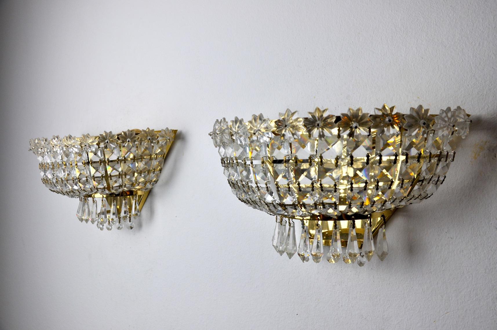 Very nice pair of Hollywood Regency sconces dating from the 80s. The sconces are made of cut rocca crystals and a gilded metal structure. Unique design object that will illuminate your interior wonderfully. Electricity checked, perfect state of