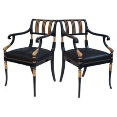 Paire de fauteuils de style Régence en ébène noirci, ornés de décorations partiellement dorées