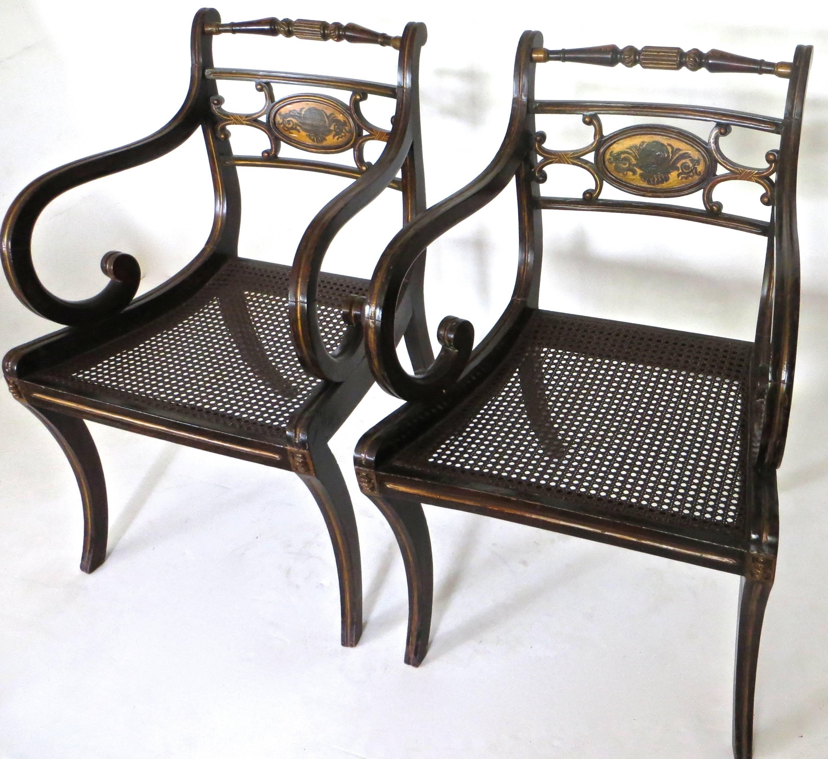 Fine pair of British Regency chairs with caned seats; the turned back has a turned crest rail; the centre oval tablet on the back is decorated.
With a shell and foliate scroll, supported and joined with a pair of 