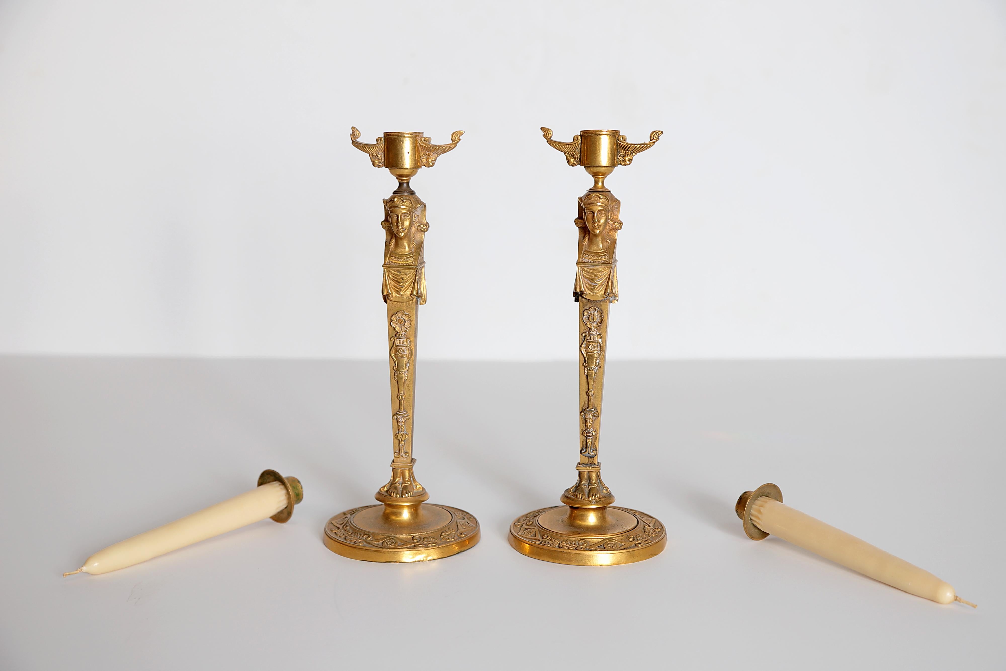 A pair of period Regency gilt bronze candlesticks. Delicate decorations and Egyptian busts at top.