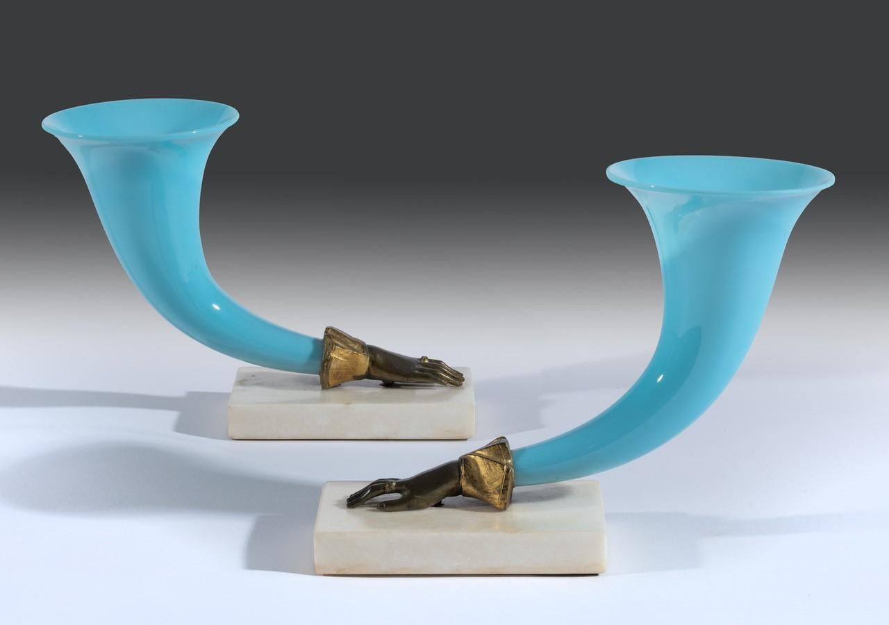 Coppia di cornucopie in vetro Regency - Il vetro blu soffiato a mano è in ottime condizioni e non presenta danni e poggia sulle basi originali in marmo statuario. Le cornucopie sono montate su mani fuse in bronzo dorato e conservano una bella patina