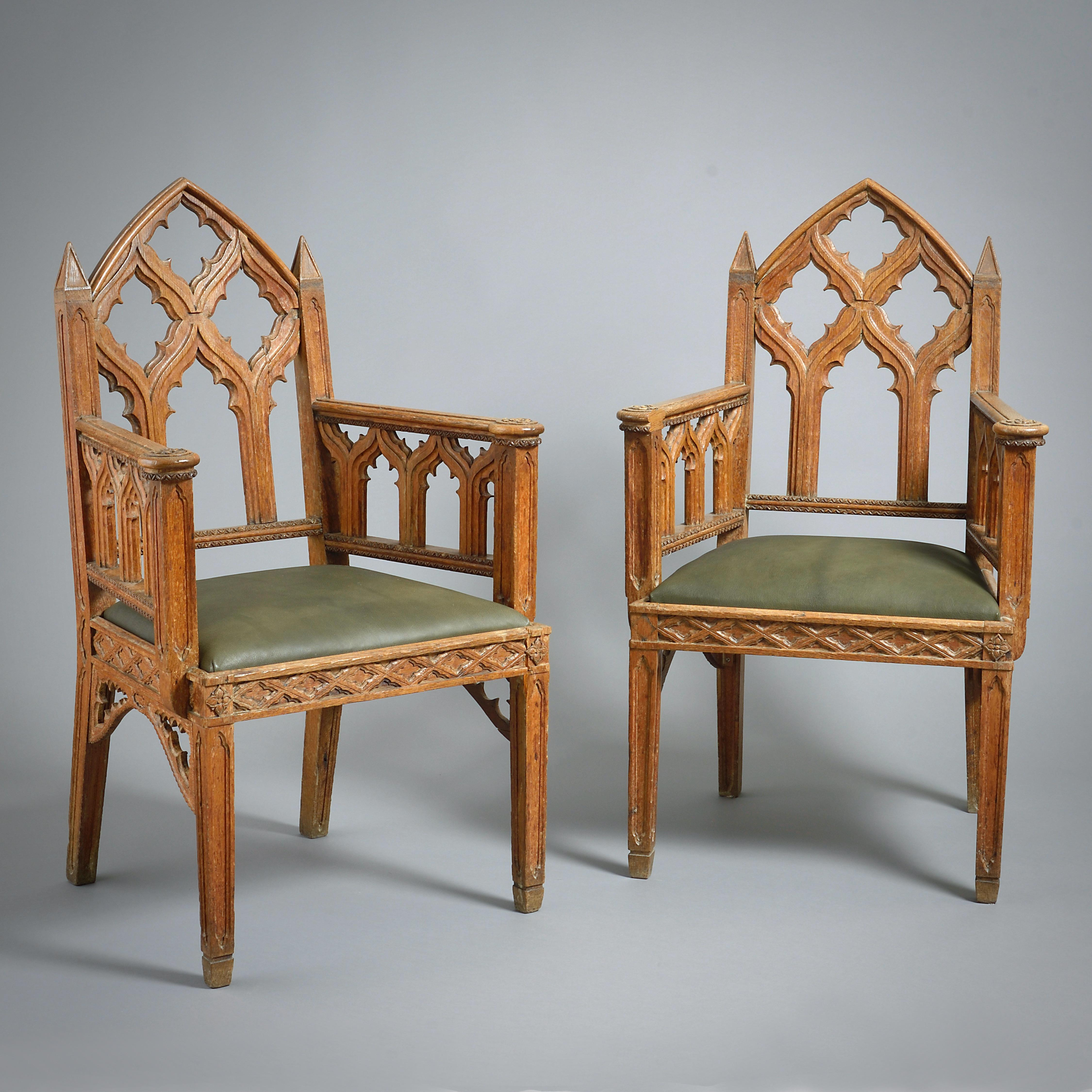 A FINE PAIR OF REGENCY GOTHIC OAK ARMCHAIRS, CIRCA 1820.

With drop-in seats upholstered in sage green goatskin.