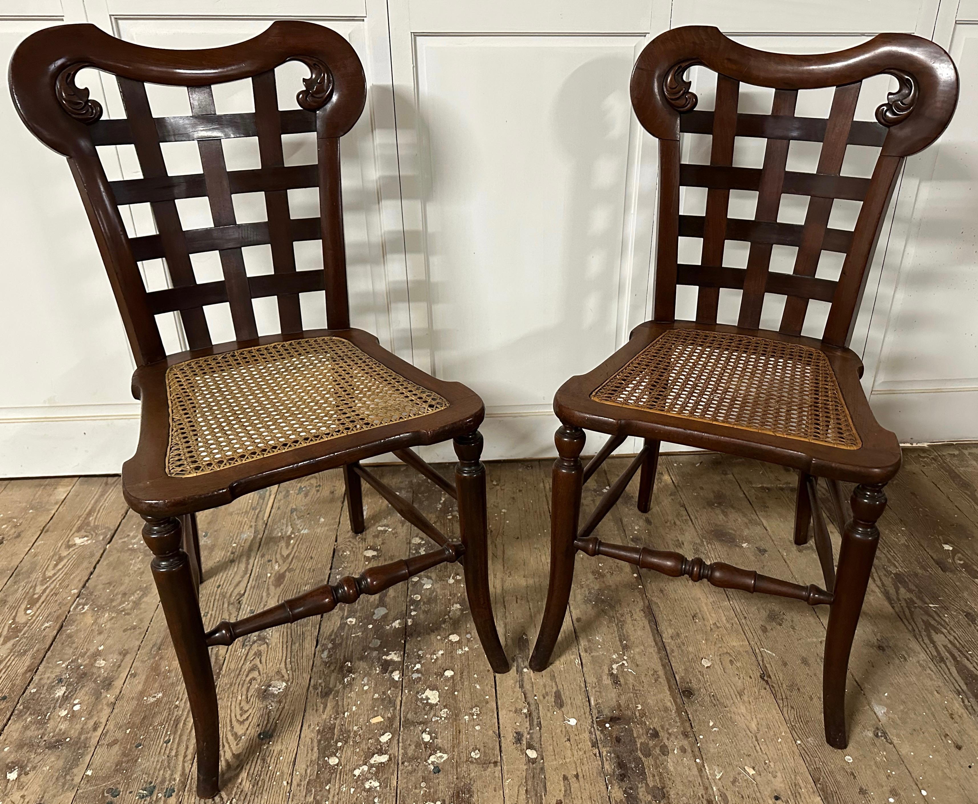 Une paire unique et inhabituelle de chaises d'appoint en acajou d'inspiration Regency du 20e siècle avec des sièges cannelés et un dossier en bois tressé sculpté.  Utilisez ces chaises comme sièges supplémentaires ou chaises d'appoint dans n'importe