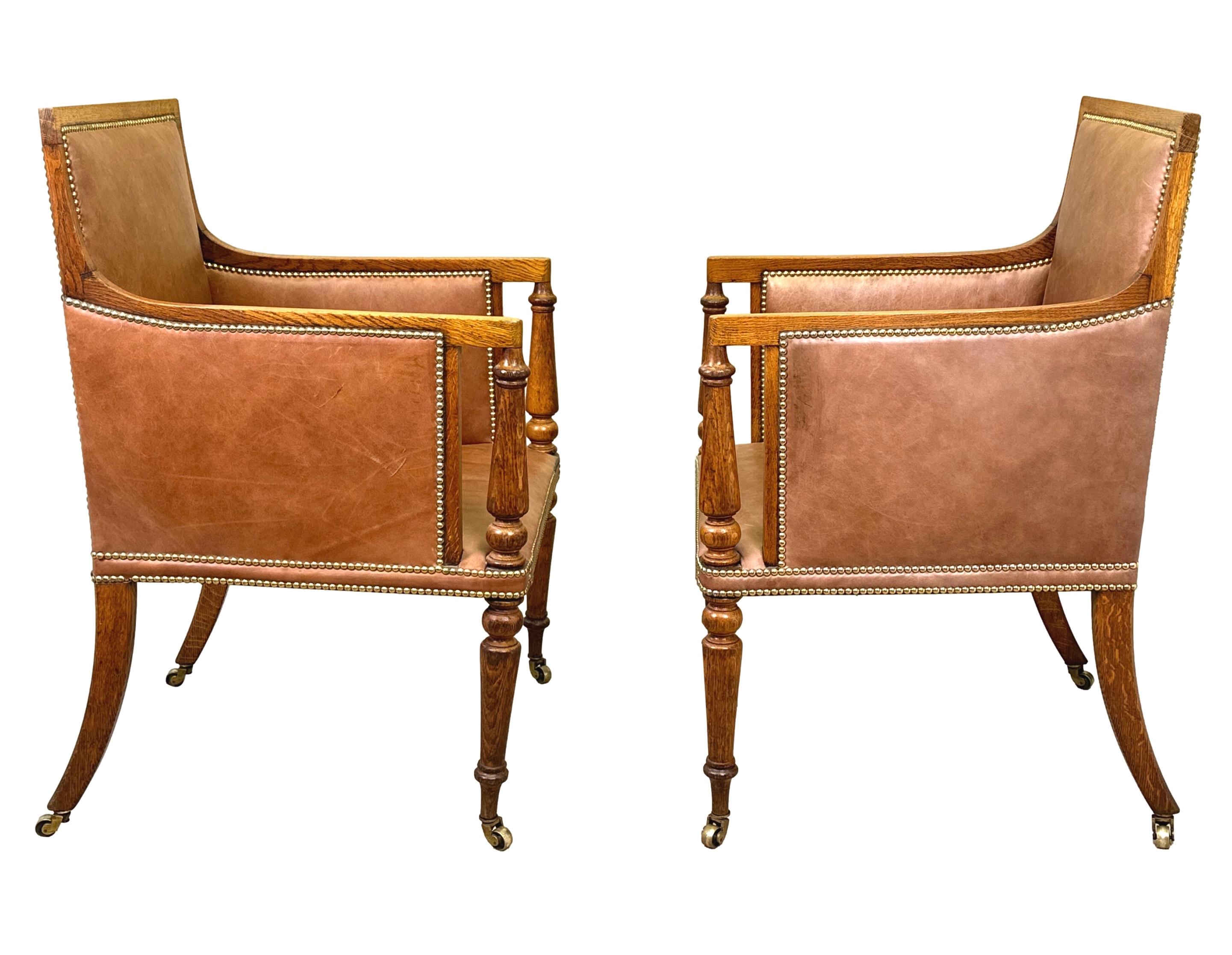An Extremely Good Quality And Unusual 19th Century, Regency Period, Pair Of Golden Oak Library Bergere Armchairs, Upholstered In Attractive Tan Leather, Having Upright Backs And Scrolling Arms With Elegant Turned Upright Supports, Raised On Fine