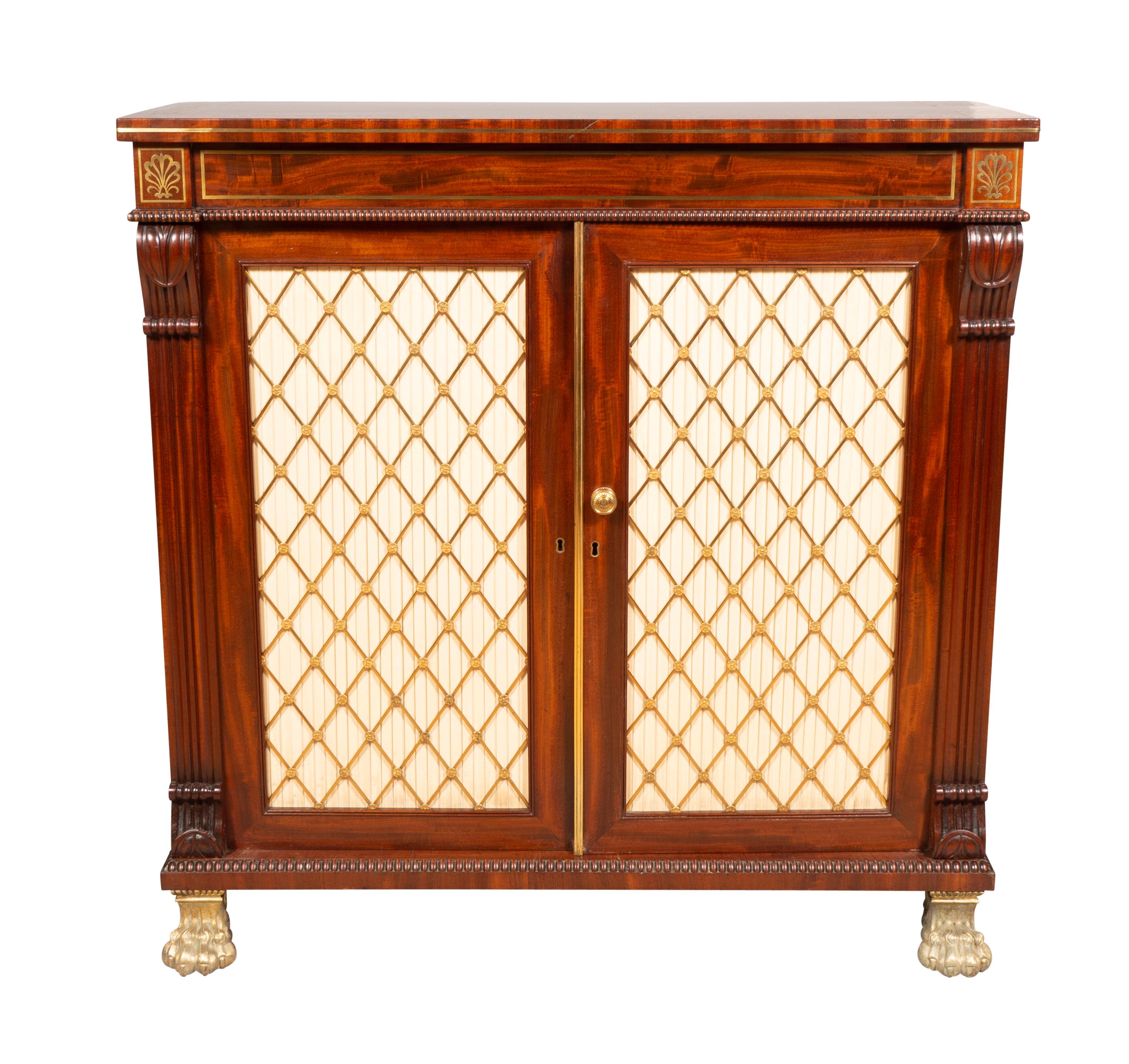 Each with a rectangular top with brass inlaid banding over a pair of brass grill doors flanked by pilasters headed by inlaid brass anthemion. Cast brass handle. Brass paw feet. Two adjustable shelves for each cabinet.

 From Westport House, County