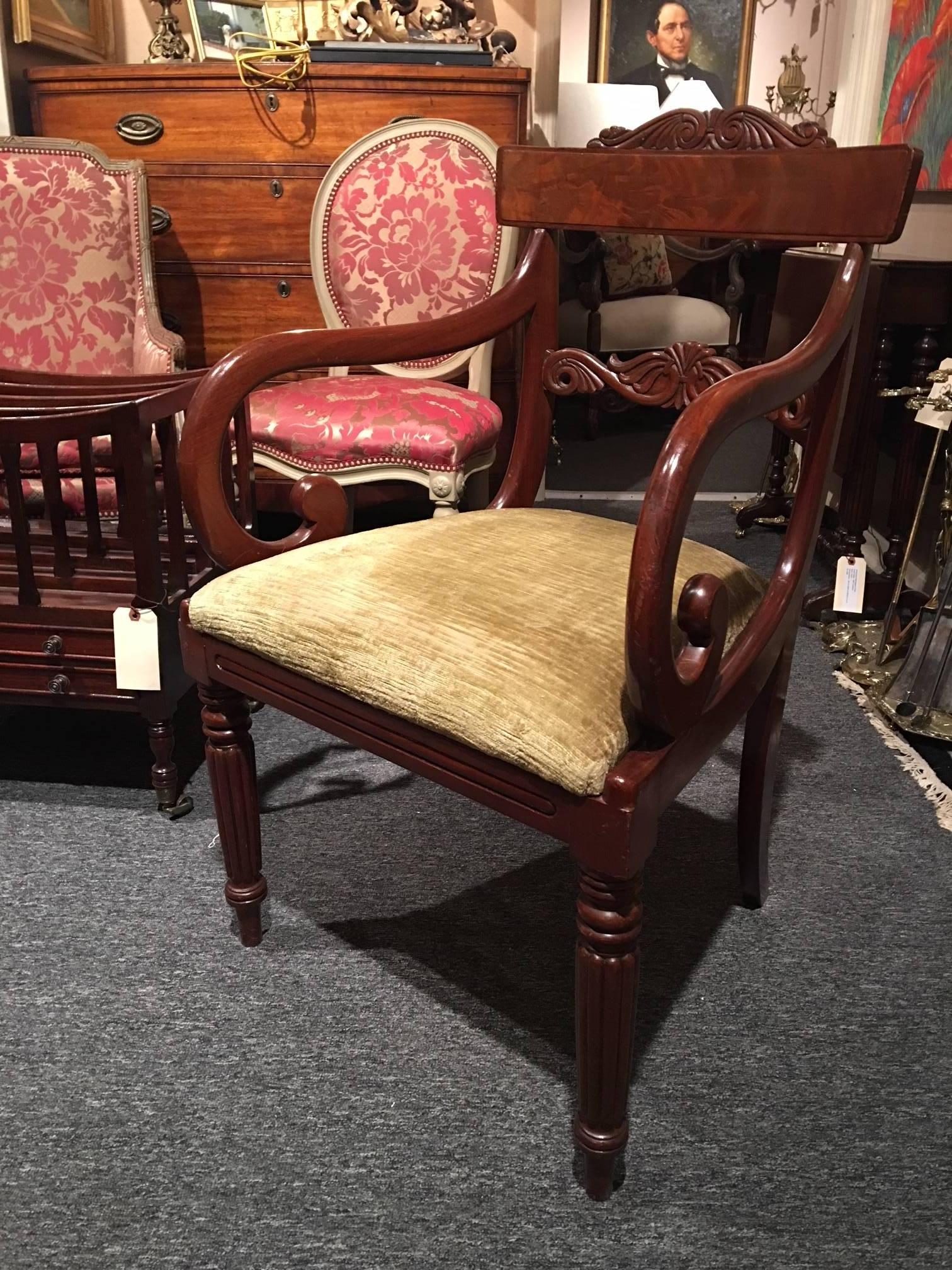 Pair of Regency mahogany armchairs standing on reeded legs with drop in seats and spay to the back legs, 19th century. The scroll of the arm is a nice design and the back splat and rest are a pleasing shape.