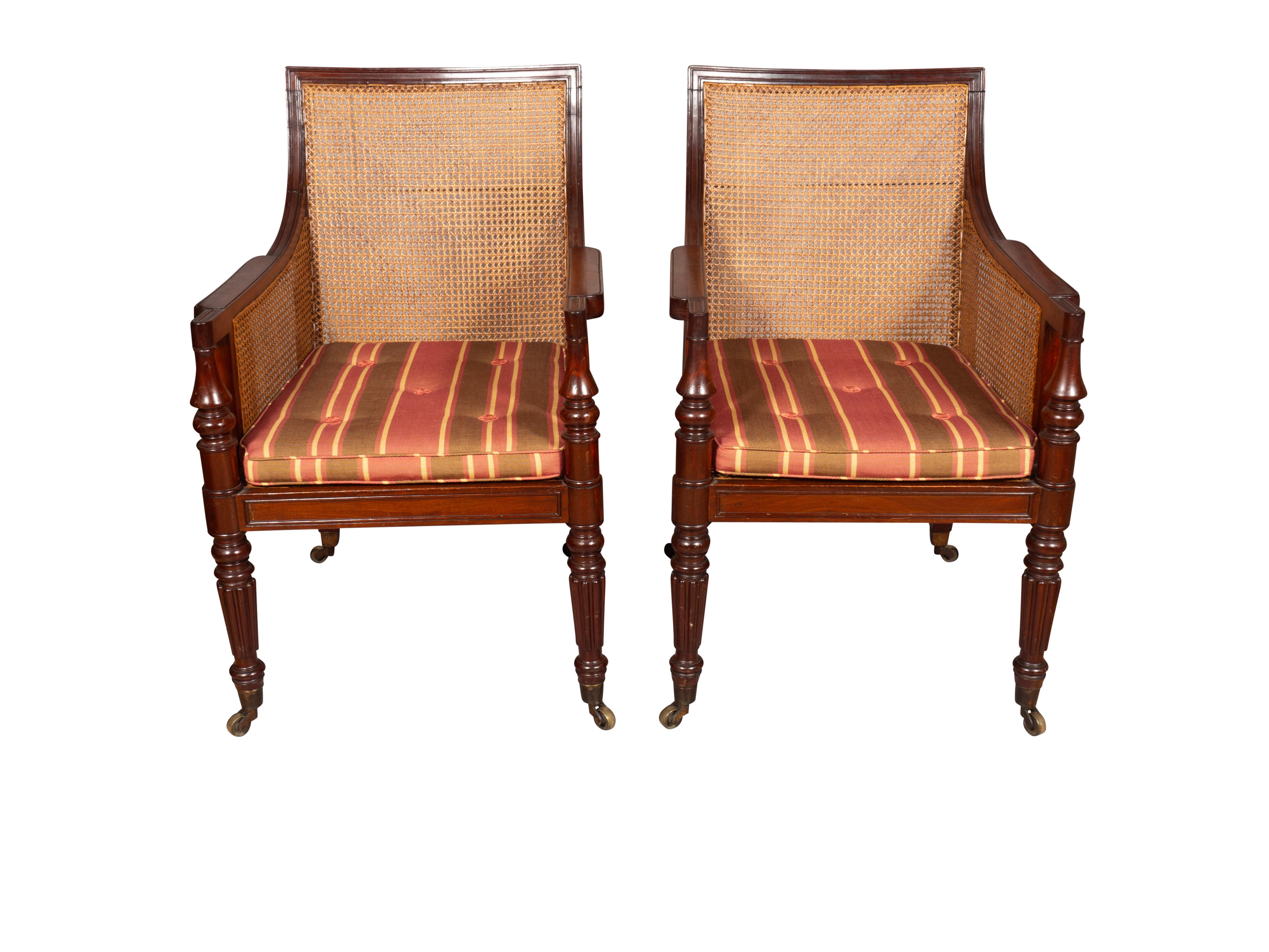 Nice pair with good caning and straight back and deep seat. Raised on turned tapered reeded legs and casters.