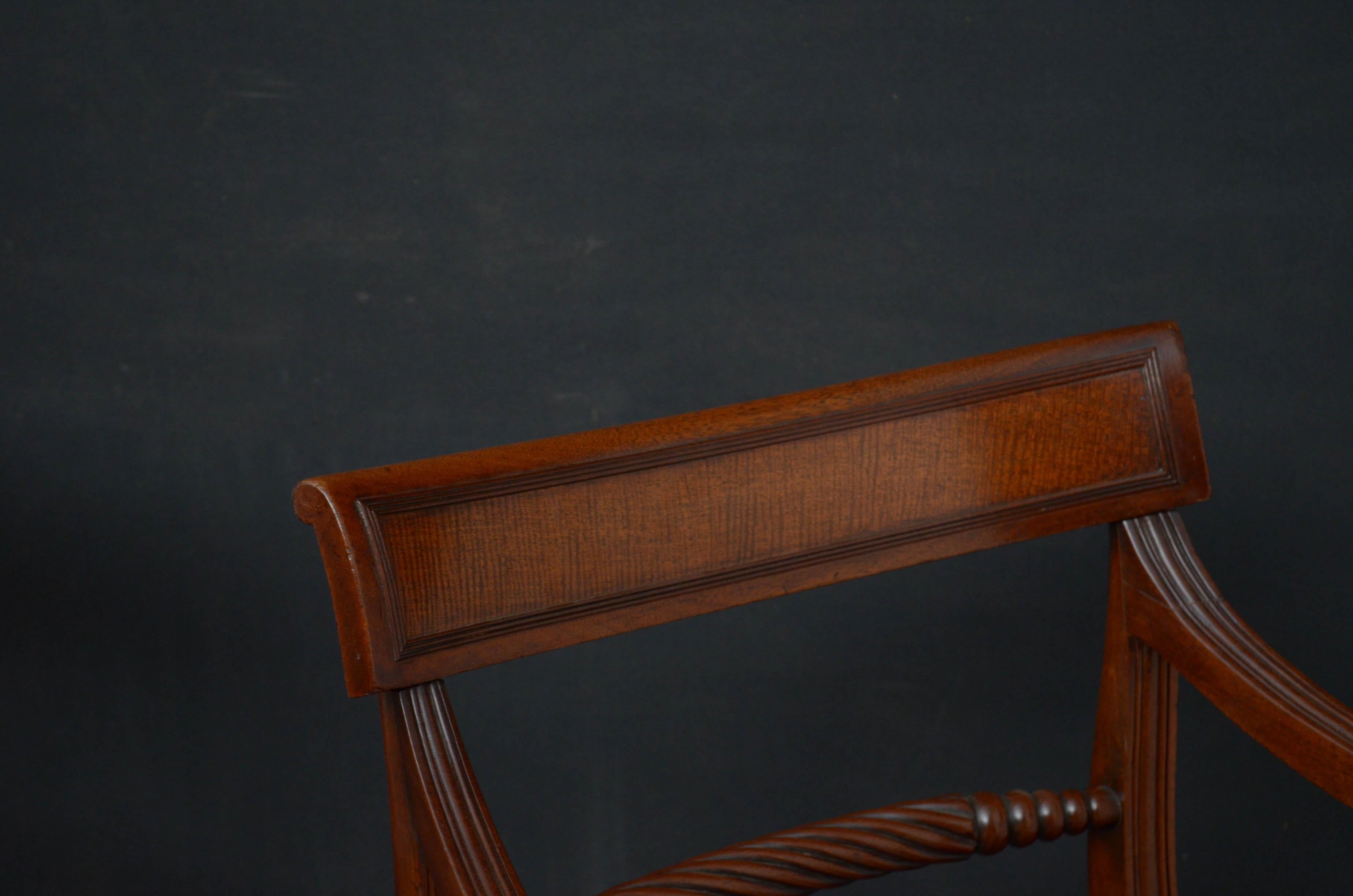 Sn4694 pair of Regency mahogany carvers, each having shaped and reeded top rail above twisted rope mid rail, stuffed over seat and open arms, standing on sabre legs. These antique armchairs have been sympathetically restored and are ready to place