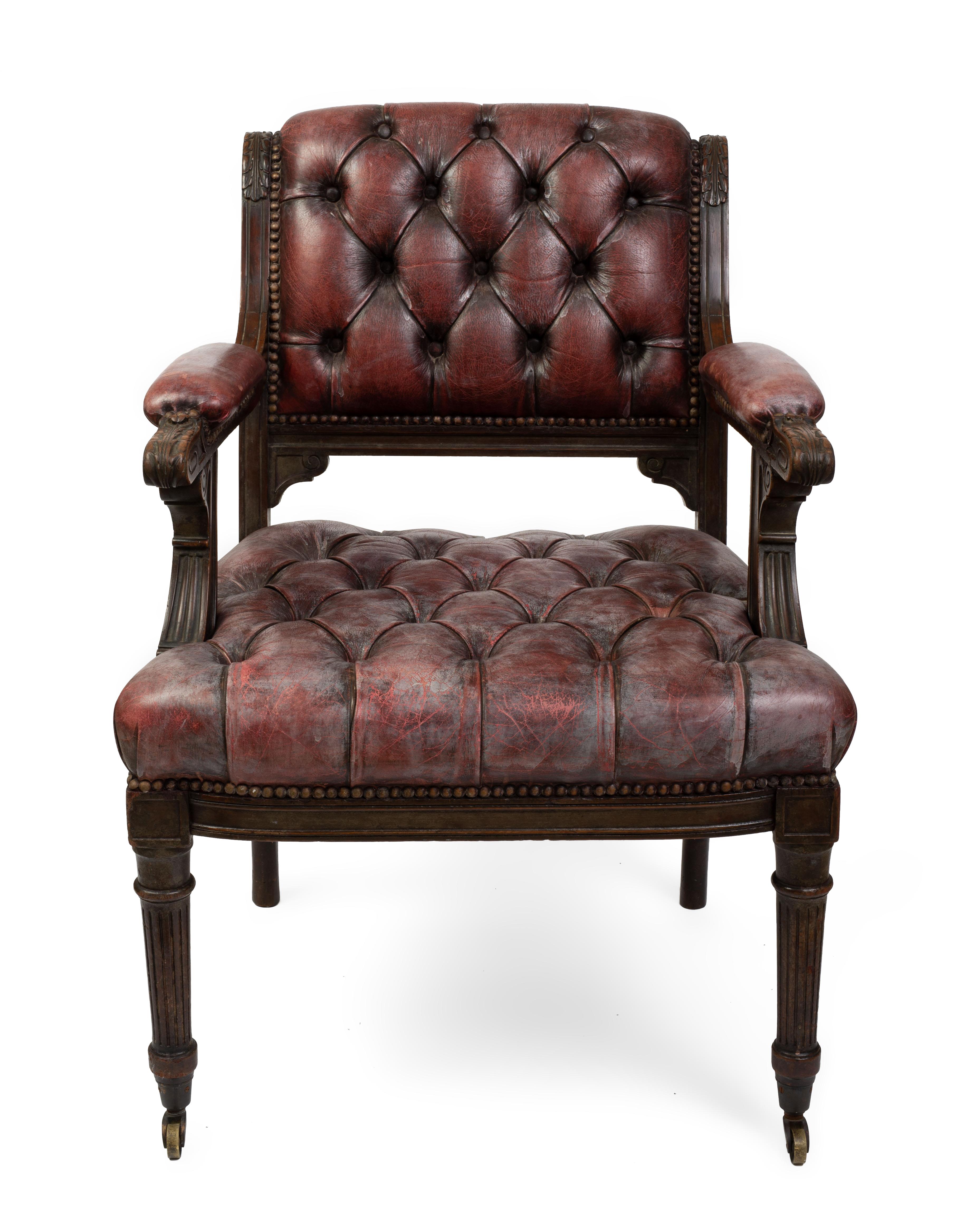 Each with a scrolled back, arms and seat with tufted upholstery, carved with acanthus leaves and Greek keys, raised on front fluted tapering legs ending in casters.