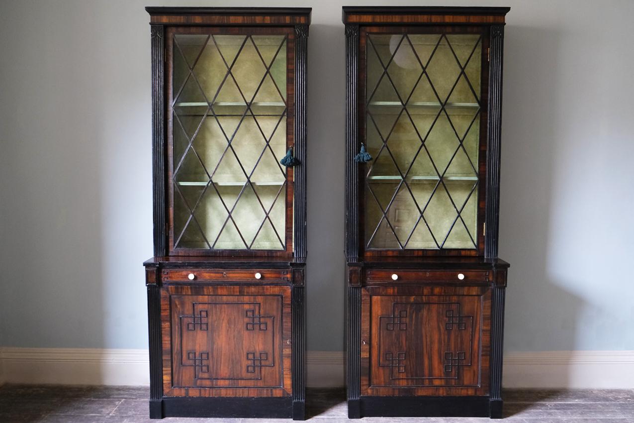 Pair of Regency mahogany library bookcases, English, circa 1830.

A pair of Regency mahogany and rosewood library bookcases. The two glazed doors enclose multiple shelves with panelled doors that are raised on a plinth base, which is inlaid with