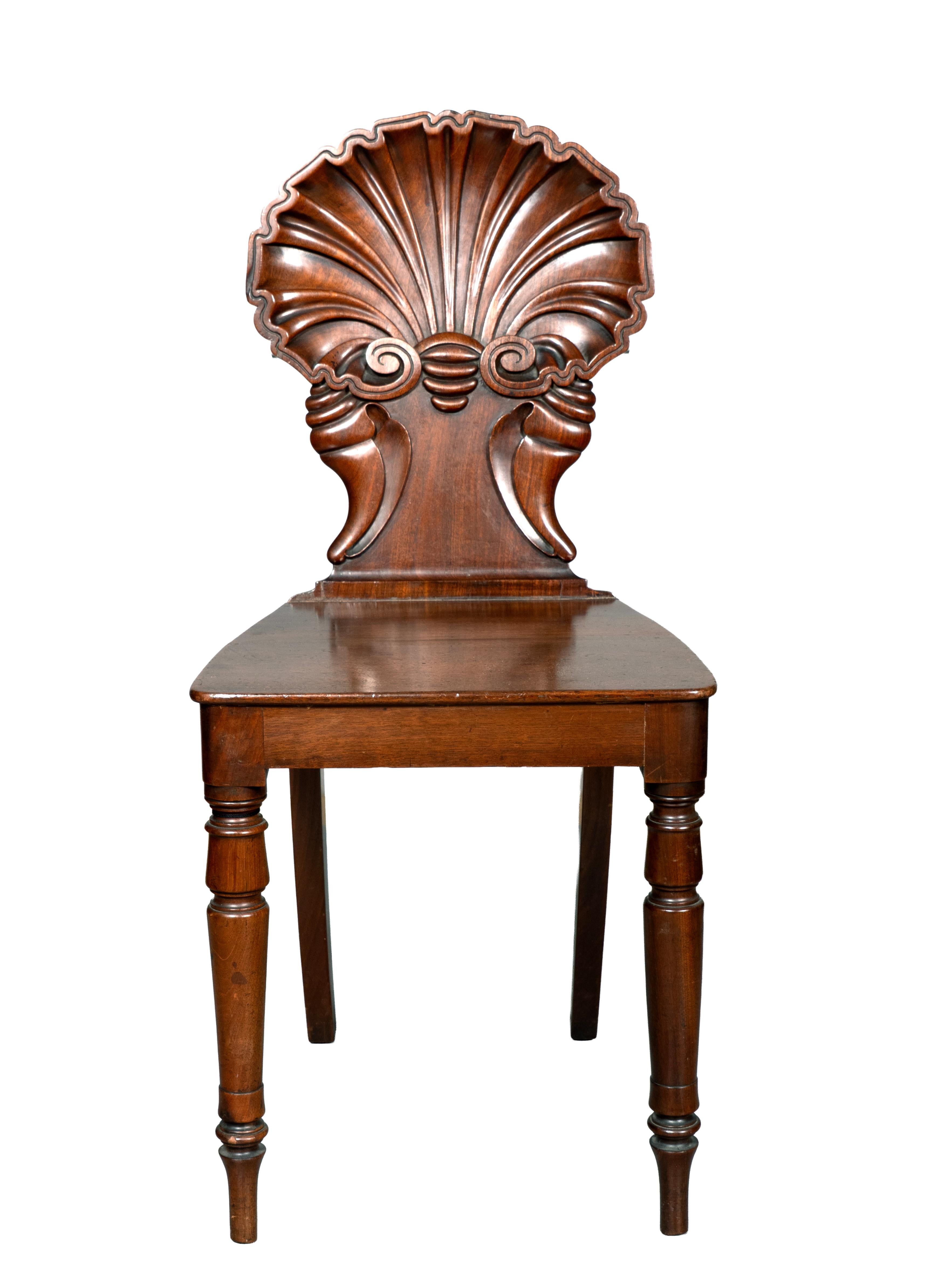 With scallop shell form carved backs with spiral shell carved splat and wood seat and circular tapered legs.