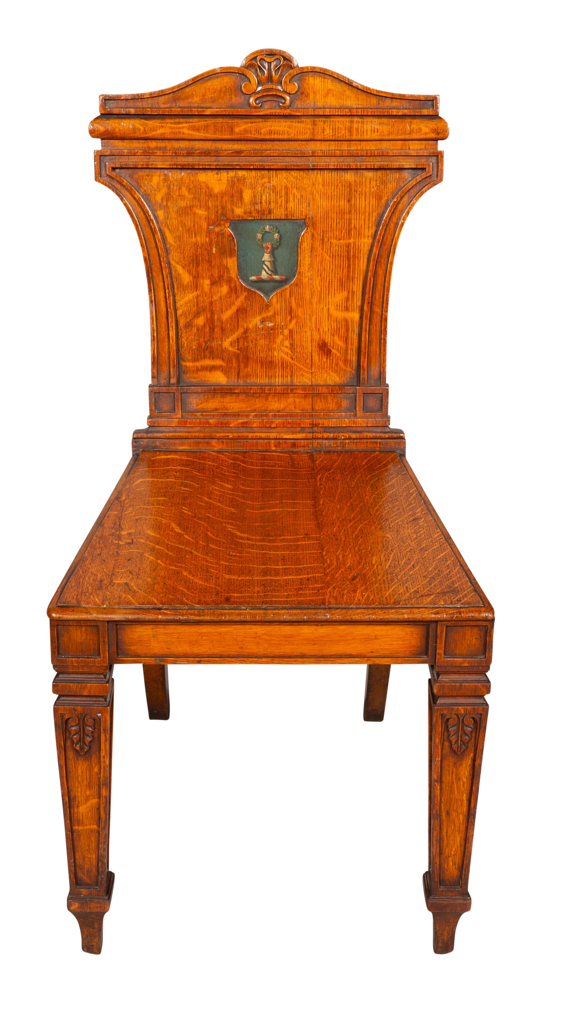 Each with a rectangular back and arched crest over a painted coat of arms, wood seat raised on square section tapered legs.