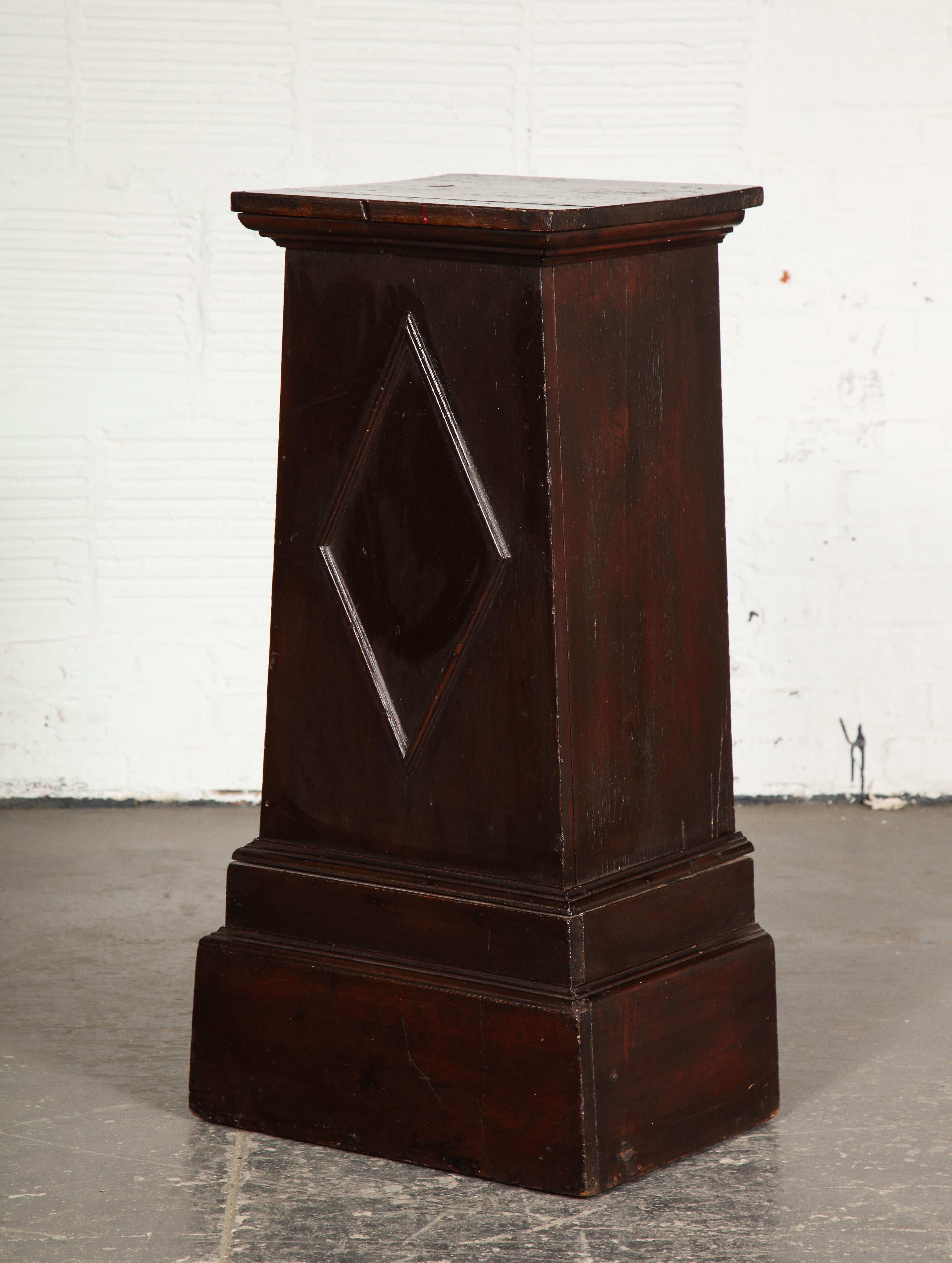 Each of square spreading form with applied diamond motif on a stepped plinth base; painted to resemble mahogany; reverse open with a shelf.