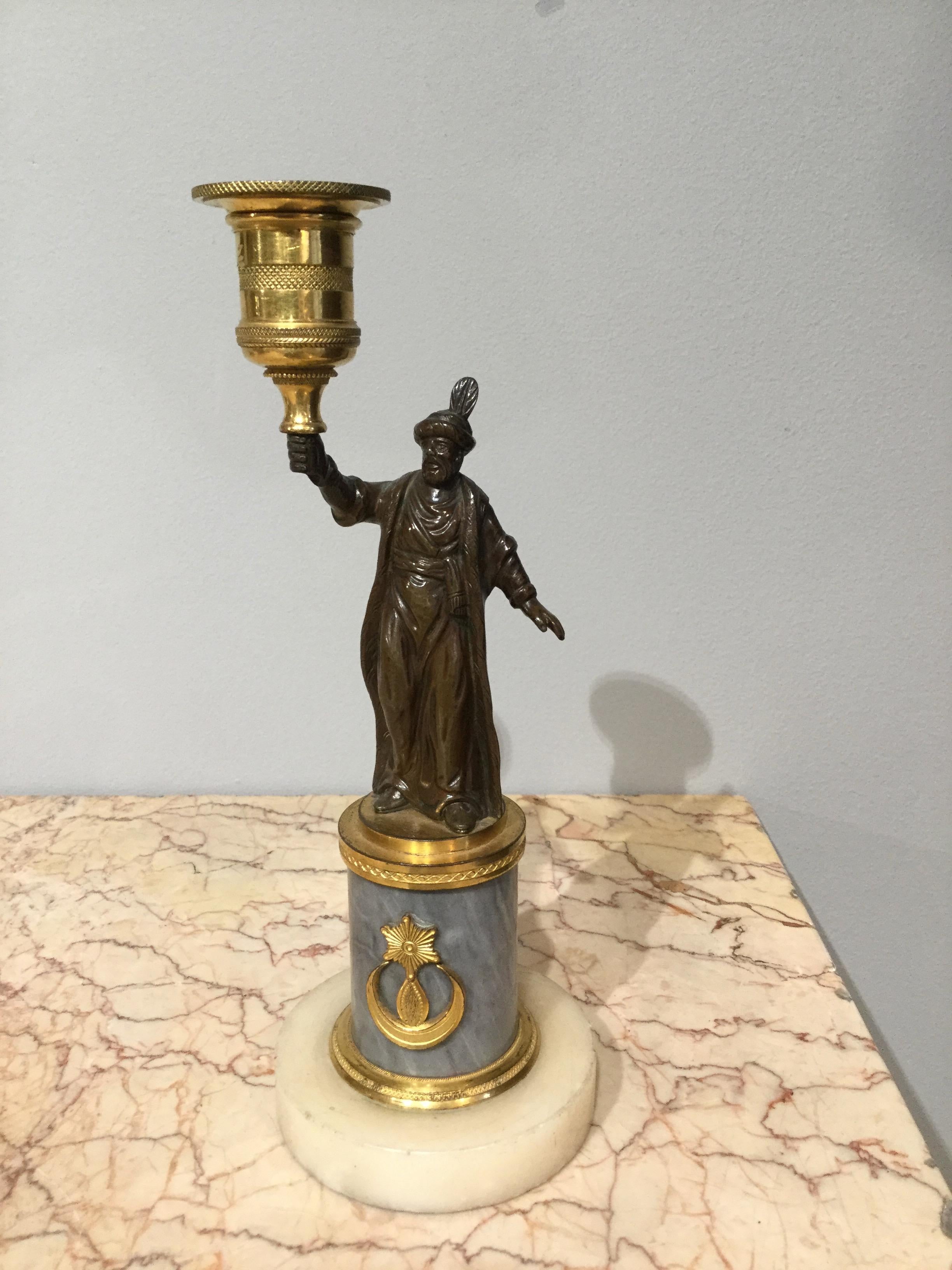 Each bronze cast Turkish figures stands on an ormolu plinth supported on a marble column with an ormolu crescent star attached. The figures hold up a chased ormolu candle nozzle.