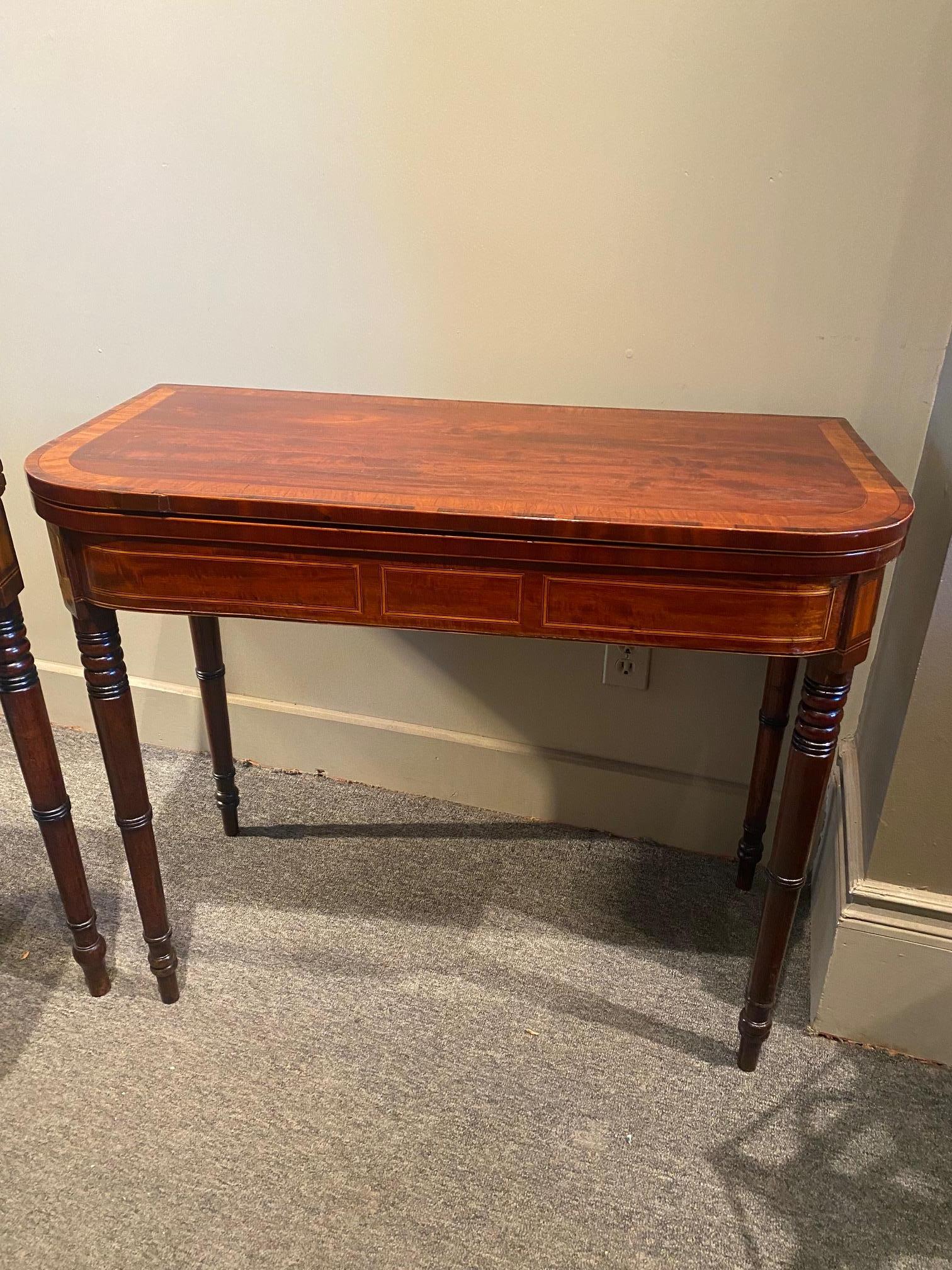 Pair of Regency period mahogany games/tea tables inlaid with boxwood crossbanding, the tops resting on turned feet , unfold to reveal a square surface , one with the felt top to play cards and the other with beautifully figured mahogany for serving