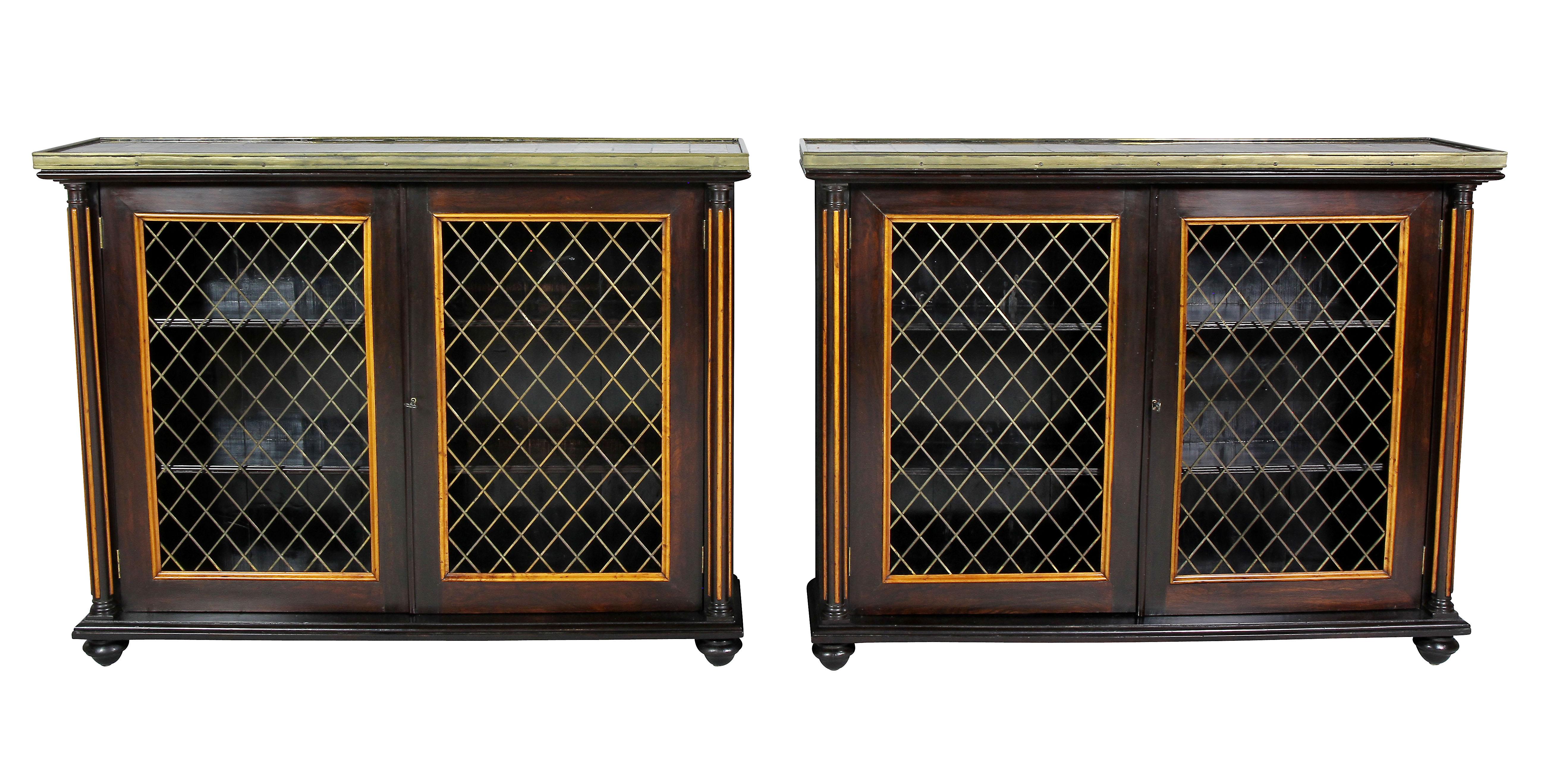 Each with a rectangular marble top comprised of various marble squares and brass banding, the conforming base each with a pair of brass grill doors enclosing shelves flanked by reeded columns. Raised on flattened toupie feet.